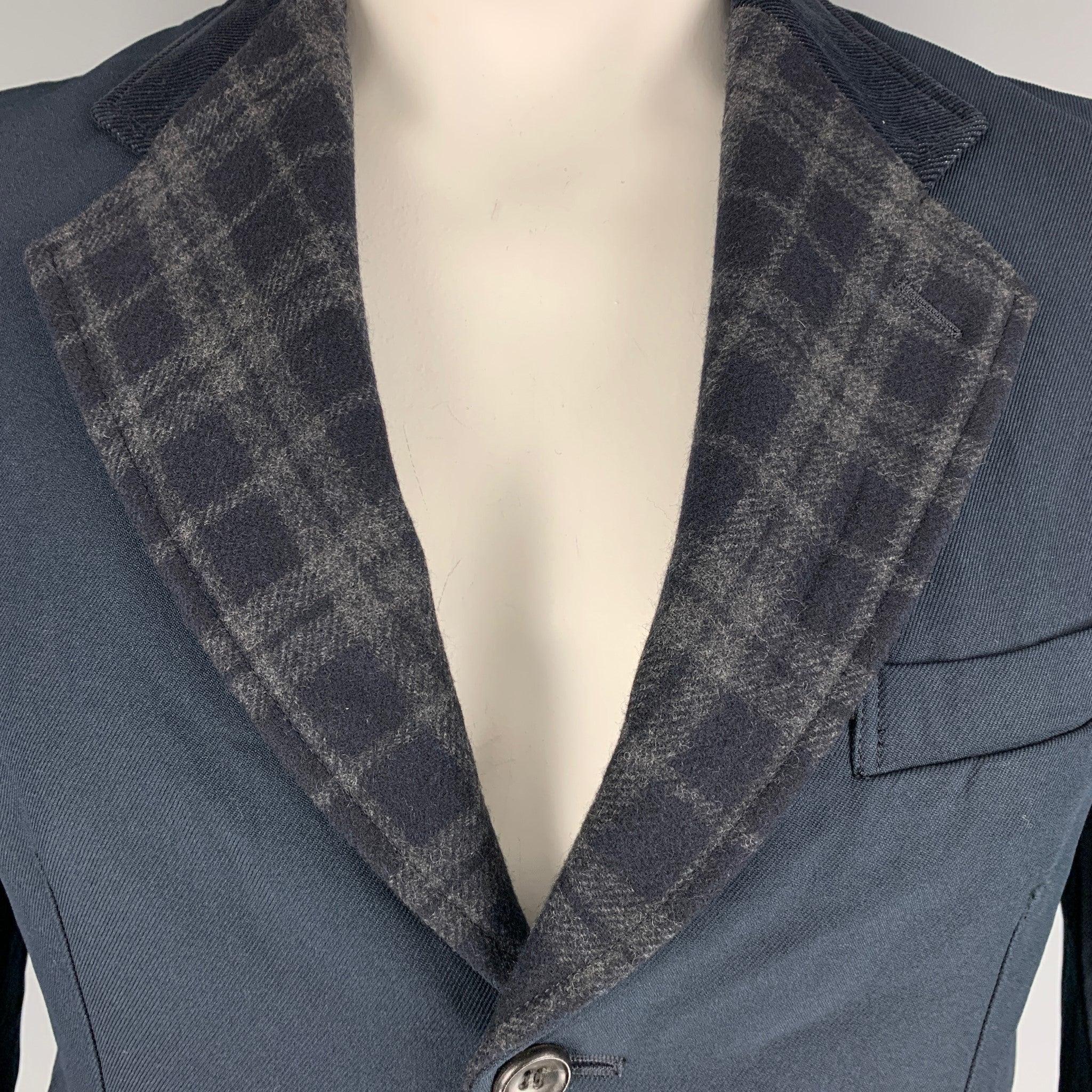 COMME des GARCONS HOMME single breasted jacket comes in navy blue polyester, featuring a plaid notch lapel, and flap pockets. Made in Japan.Excellent Pre-Owned Condition. 

Marked:   L 

Measurements: 
 
Shoulder: 19 inches Chest: 40 inches Sleeve: