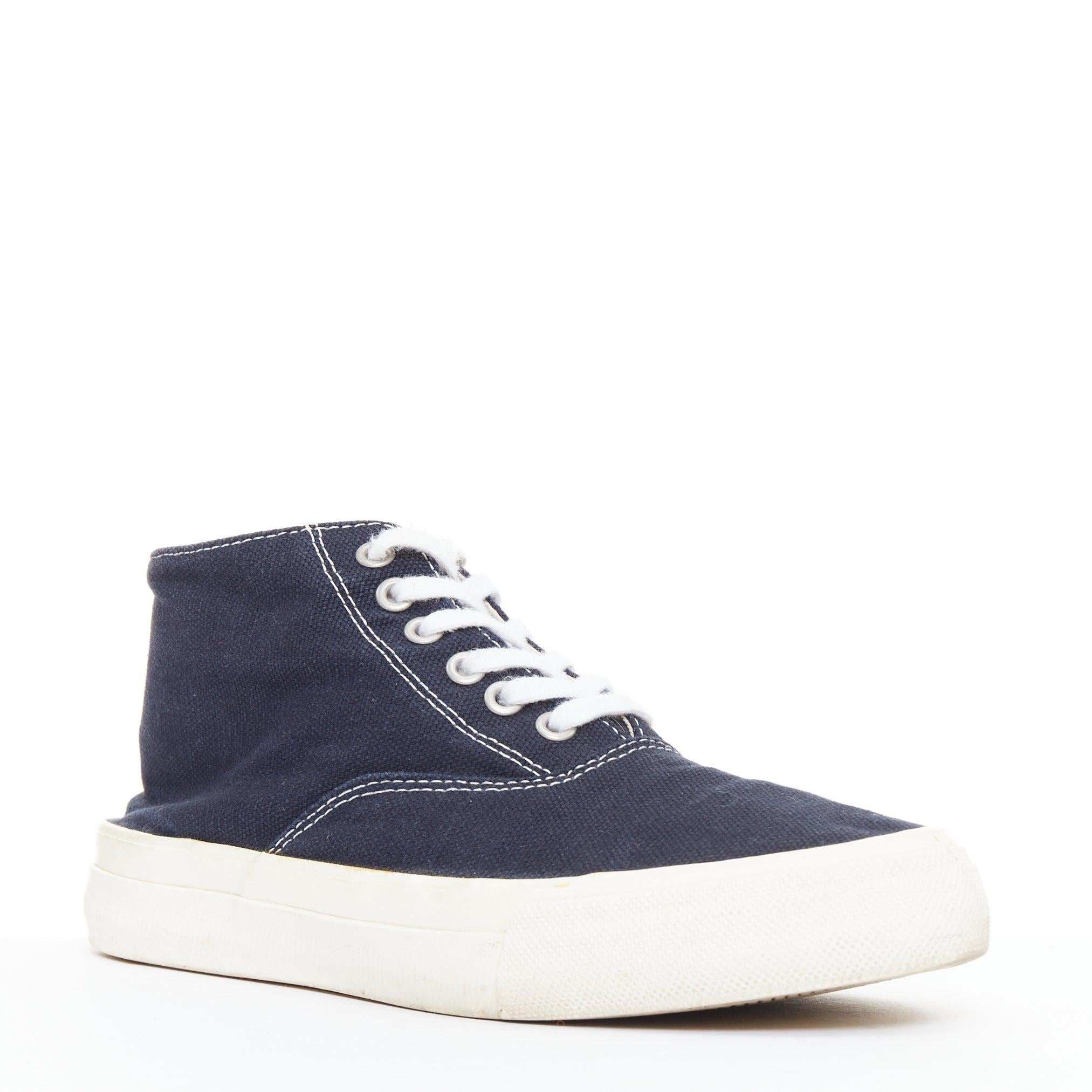 COMME DES GARCONS Homme navy canvas mid top skate sneakers EU39
Reference: CNLE/A00428
Brand: Comme Des Garcons
Collection: Homme
Material: Canvas
Color: Navy, Cream
Pattern: Solid
Closure: Lace Up
Lining: Beige Fabric

CONDITION:
Condition: Fair,