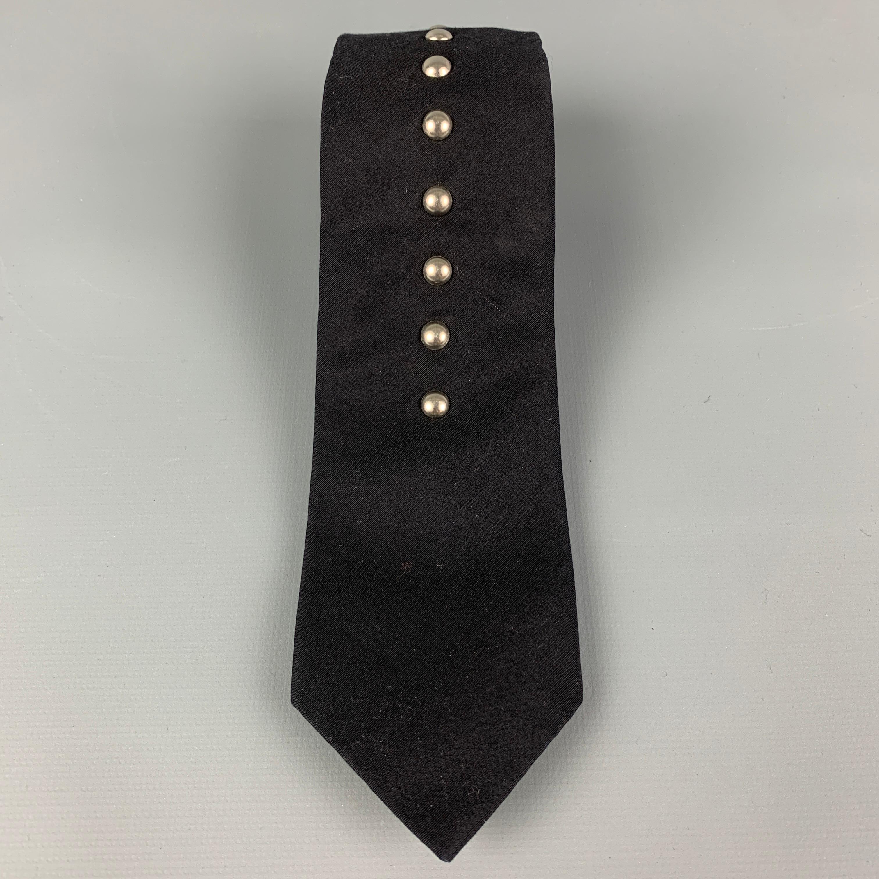 COMME des GARCONS HOMME PLUS skinny necktie comes in a black material featuring a 10 silver tone studded design. 

Very Good Pre-Owned Condition.

Measurements:

Width: 2.5 in. 