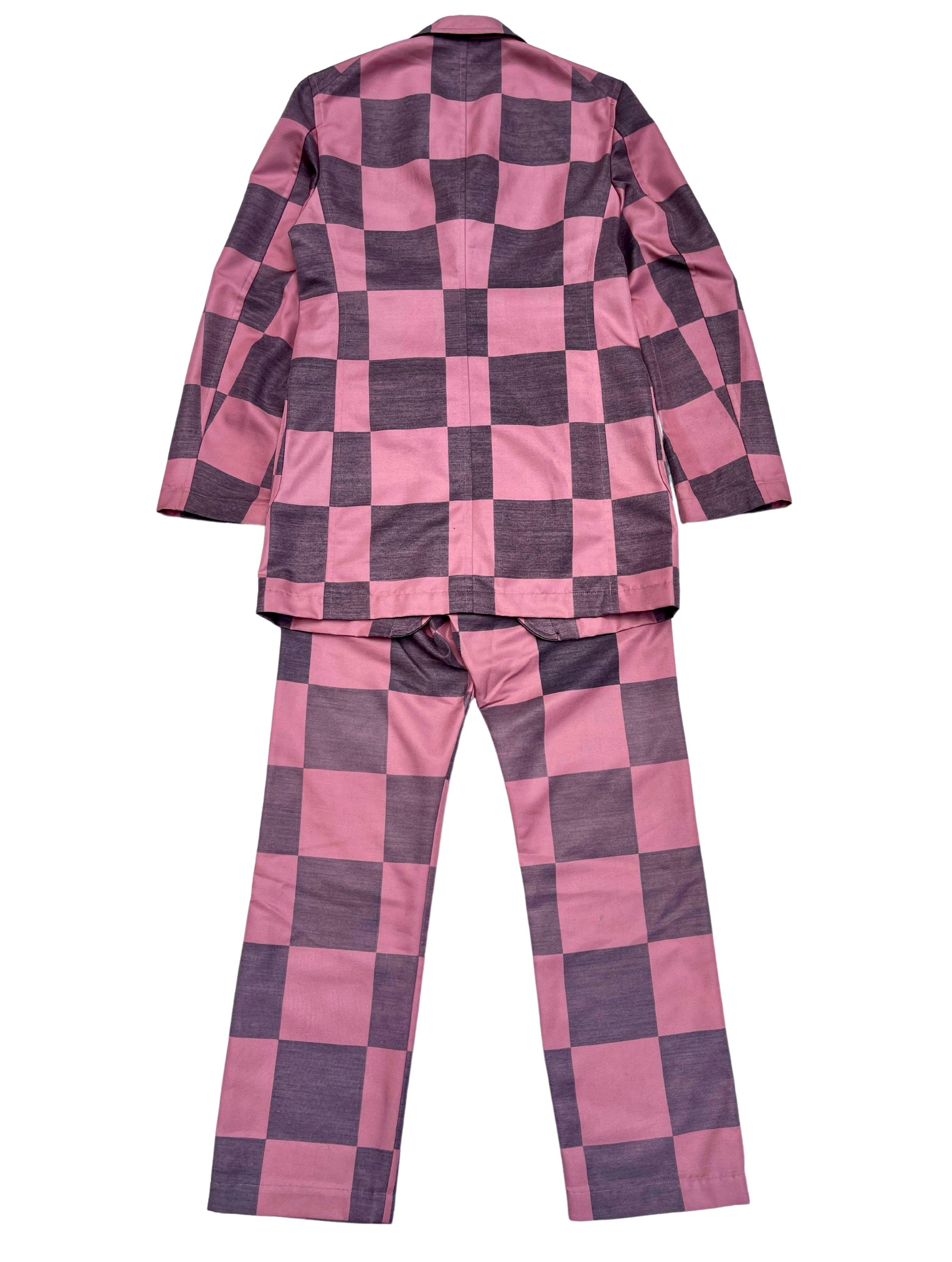 Vintage COMME des GARCONS HOMME PLUS checkered suit comes in black, pink textured wool with a notch lapel, single breasted three button front, bold checkered lining. The pants featured matching patterns. A collectors item. Made in Japan.

Size on