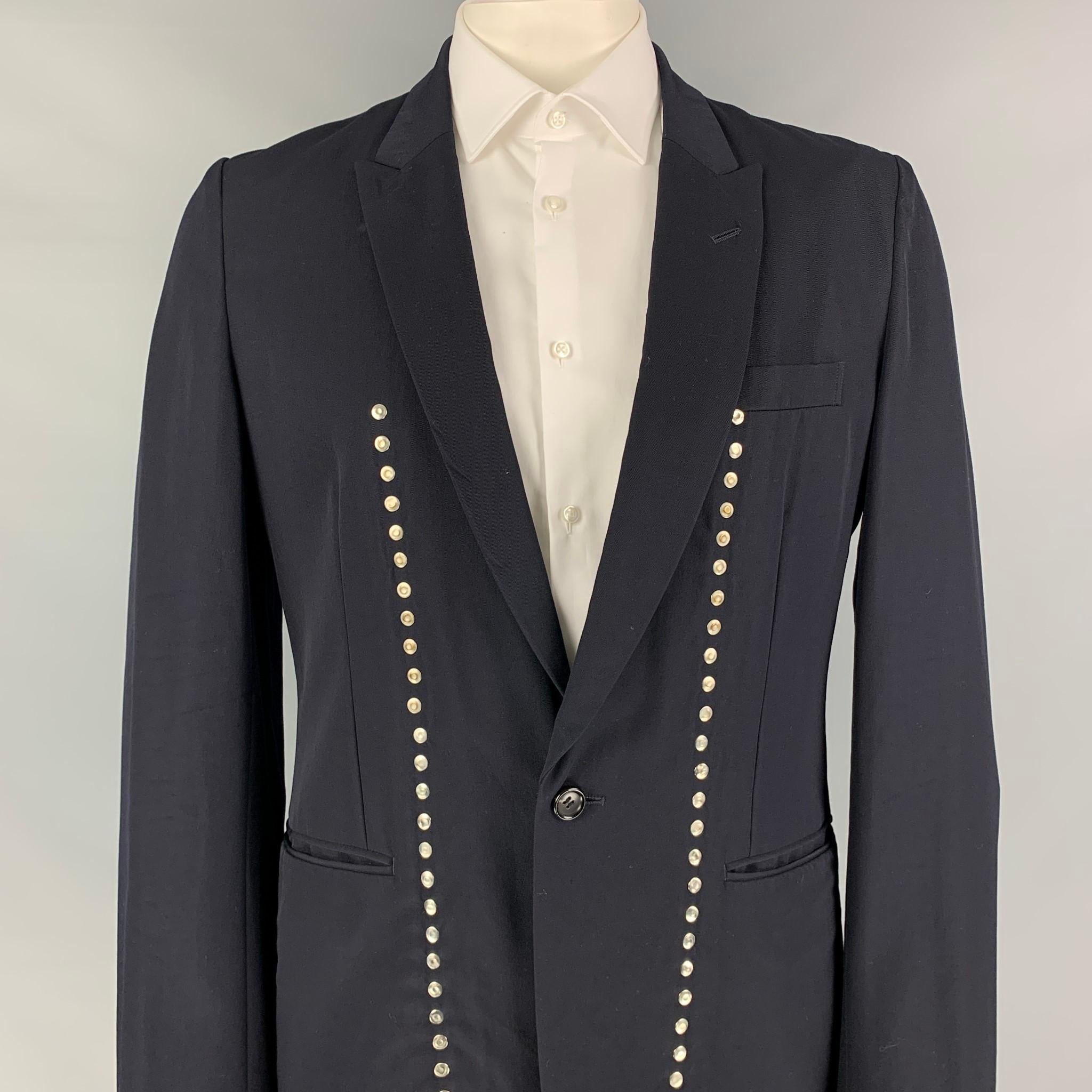 COMME des GARCONS HOMME PLUS EVERGREEN sport coat comes in a navy wool featuring a peak lapel, studded details, slit pockets, single back vent, and a single button closure. Made in Japan. 

Very Good Pre-Owned Condition.
Marked: L /