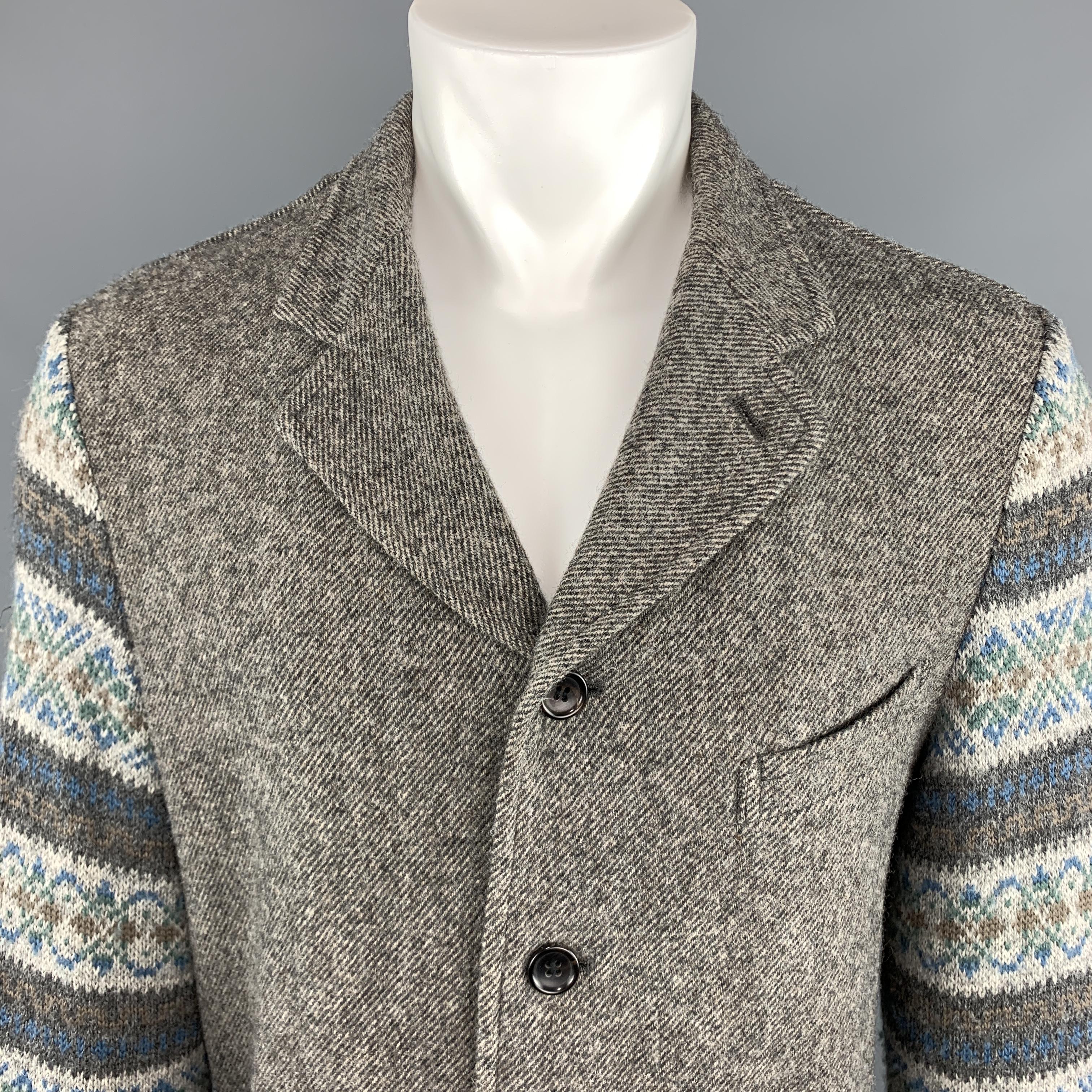 COMME des GARCONS HOMME PLUS sport jacket comes in heather taupe gray wool knit twill with a single breasted four button front, notch lapel, patch pockets, and blue and gray fairisle knit sleeves. Made in Japan.
 
Excellent Pre-Owned