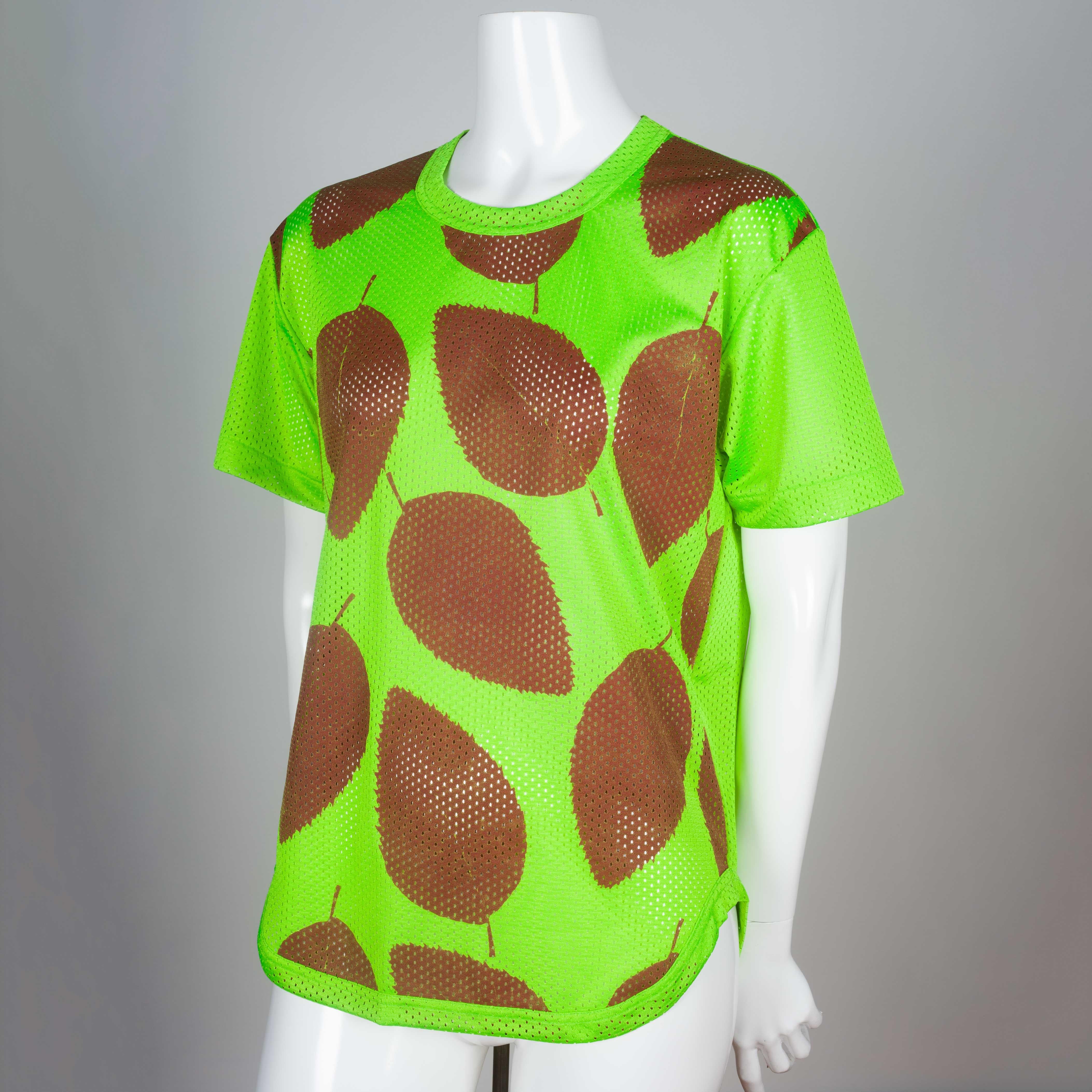 Comme des Garçons Homme Plus from 2000, a neon green textured mesh t-shirt from Japan with deep brown sienna screen-printed leaves. The contrast of material, theme and color is a perfect signature of Kawakubo magic in everyday clothing. Think the