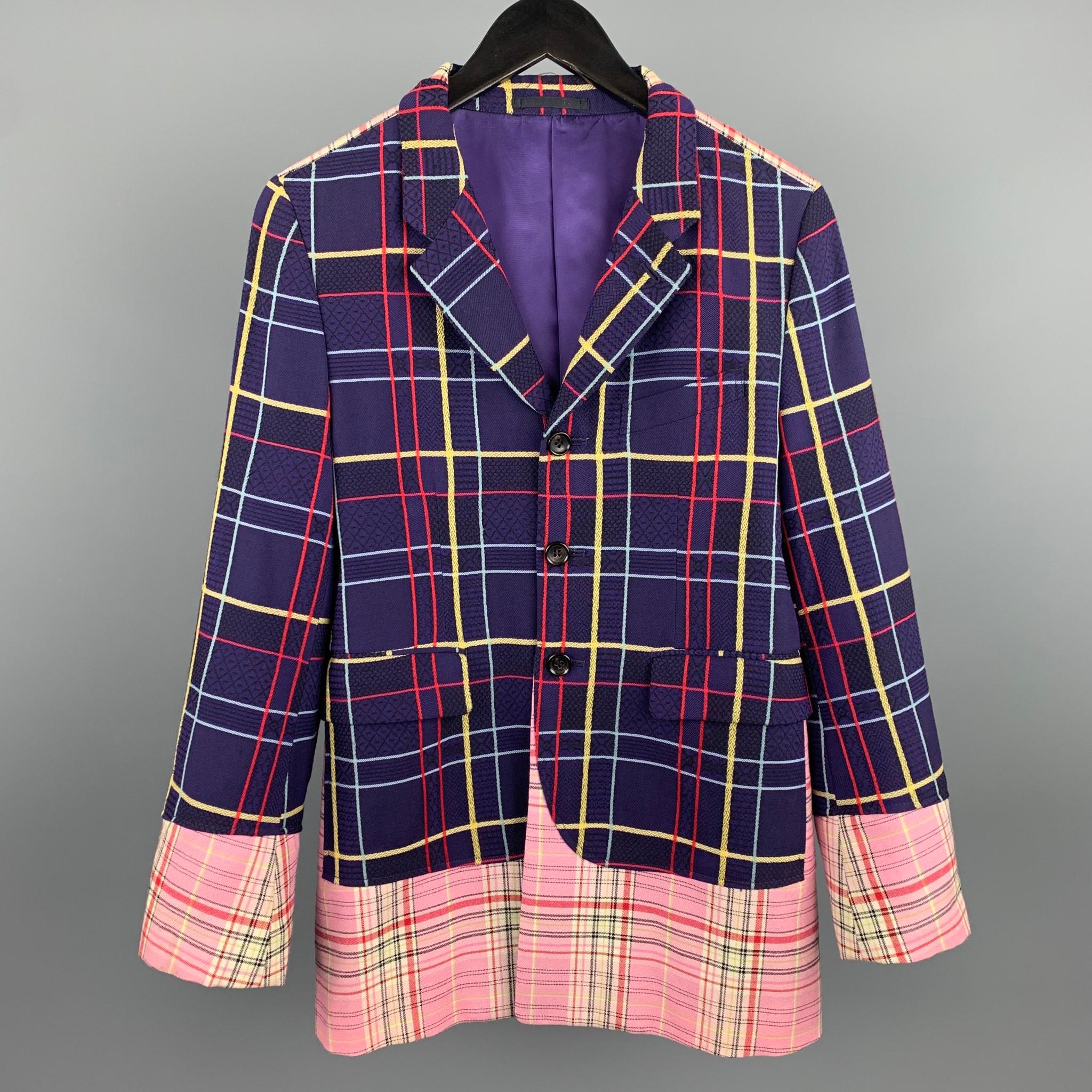 This rare vintage COMME des GARCONS HOMME PLUS AD2000 Docking mixed plaid suit comes in a bold purple, red and pink plaid textured wool with a notch lapel, single breasted three button front, bold purple lining, and pink plaid panels throughout. The