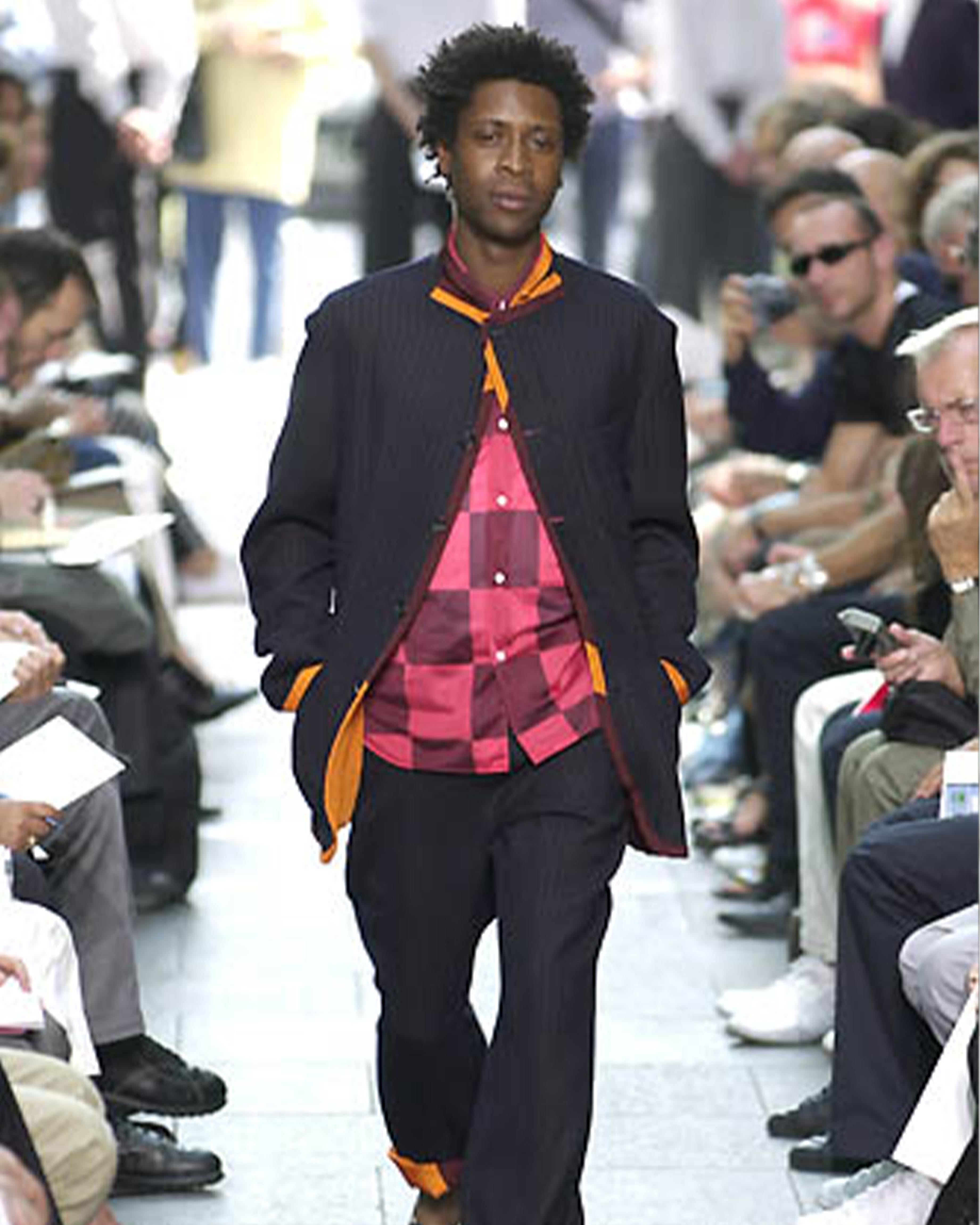 - Diseñado por Rei Kawakubo
- Colección primavera verano 2001
- Blazer azul a rayas multicolor
- Detalles multicolores en rojo y naranja
- Cuello versátil
- Cierre frontal con botones
- Diseño de bolsillos frontales de árbol
- Diseño de finas líneas