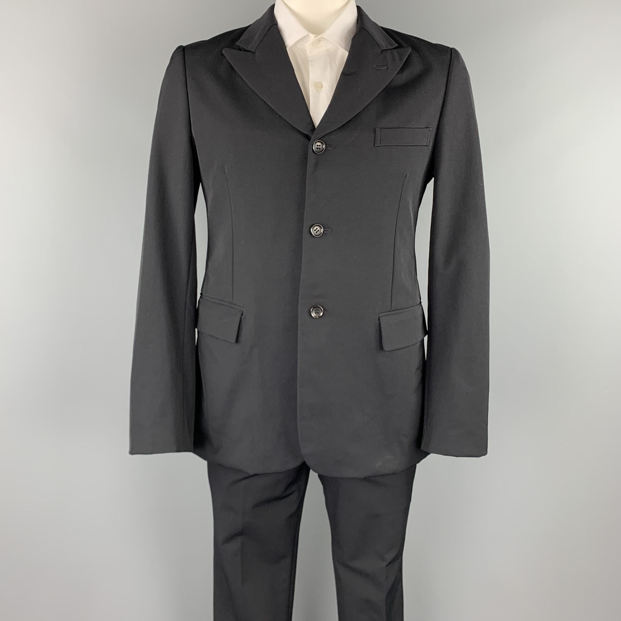 COMME des GARCONS HOMME PLUS suit comes in a black with a full liner and includes a single breasted, three button sport coat with a peak lapel and matching flat front trousers. Made in Japan.

Excellent Pre-Owned Condition.
Marked:
