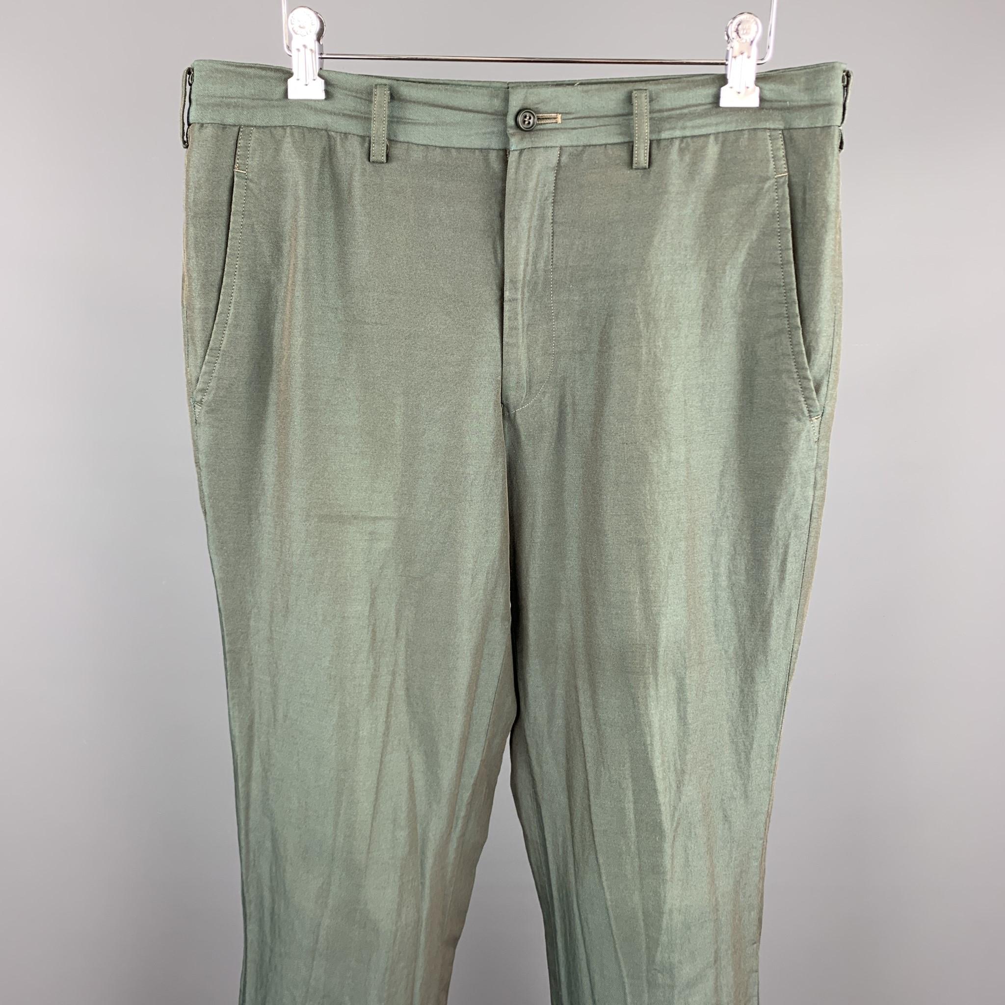 COMME des GARCONS HOMME PLUS casual pants comes in a green two toned iridescent featuring a flat front, cuffed legs, and a zip fly closure. Made in Japan. 

Good Pre-Owned Condition.
Marked: M AD2014

Measurements:

Waist: 32 in. 
Rise: 9 in.