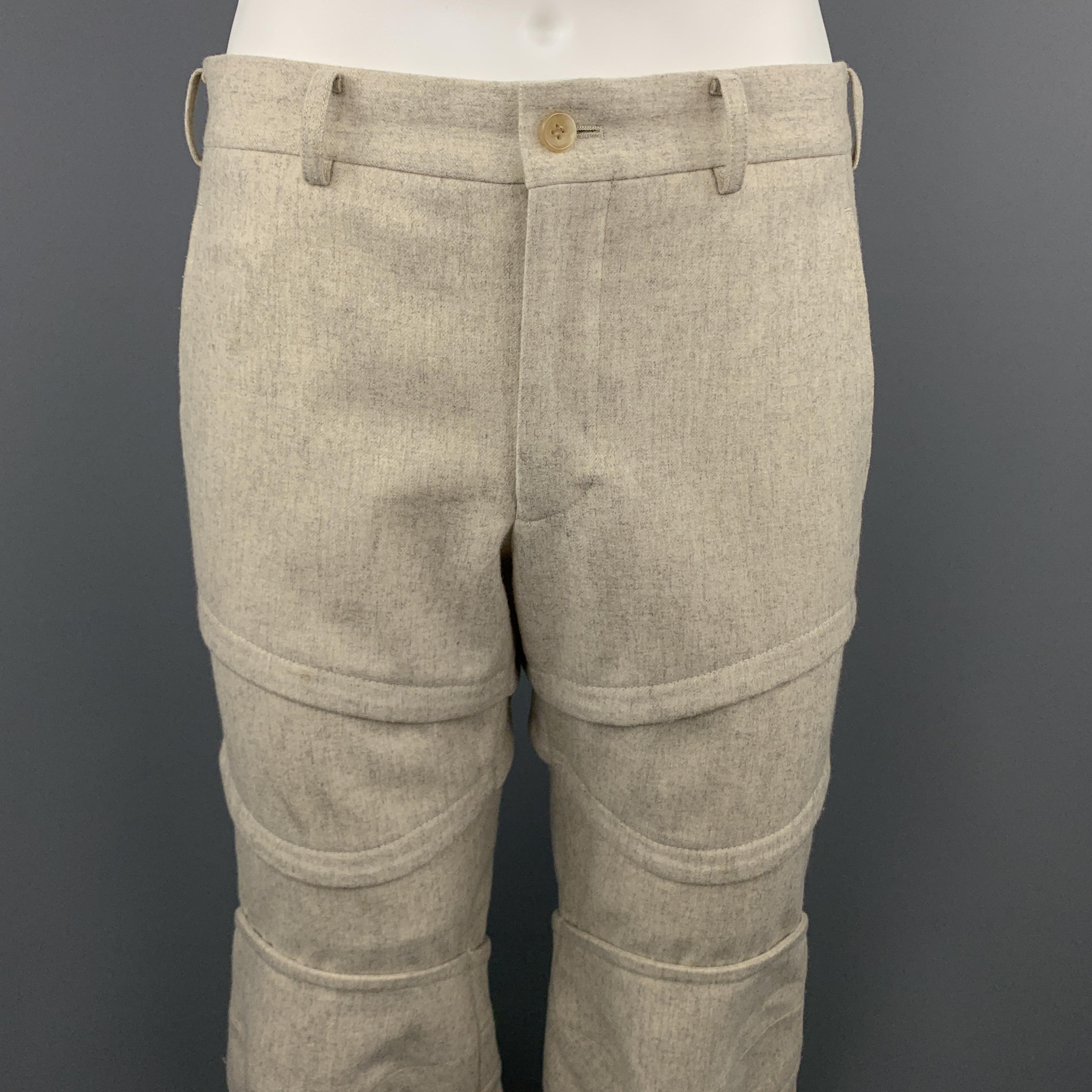 COMME des GARCONS HOMME PLUS pants come in oatmeal beige heathered wool blend flannel with layered armor inspired panels throughout the leg and knee pads. Made in Japan.

Excellent Pre-Owned Condition.
Marked: M  AD 2016

Measurements:

Waist: 34.5