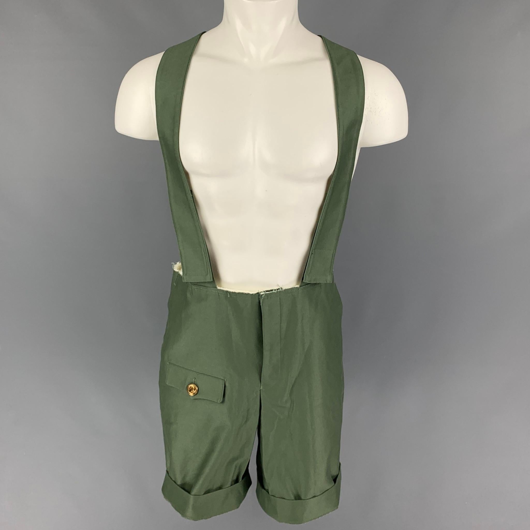 COMME des GARCONS HOMME PLUS overalls comes in a green cotton featuring adjustable suspenders, raw edge, gold tone button detail, and a zip fly closure. Made in Japan. 

Excellent Pre-Owned Condition.
Marked: S / AD2014

Measurements:

Waist: 36