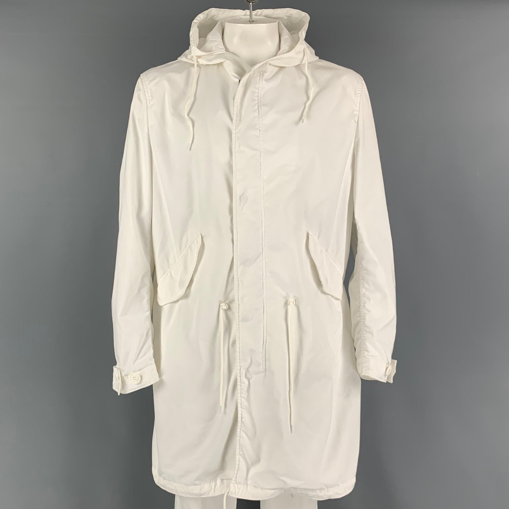 COMME des GARCONS HOMME AD2018 long coat comes in a white polyester material featuring a parka hooded style, large flap pockets, oversized fit, drawstring details, and a hidden zip & snap button closure. Made in Japan.

Very Good Pre-Owned