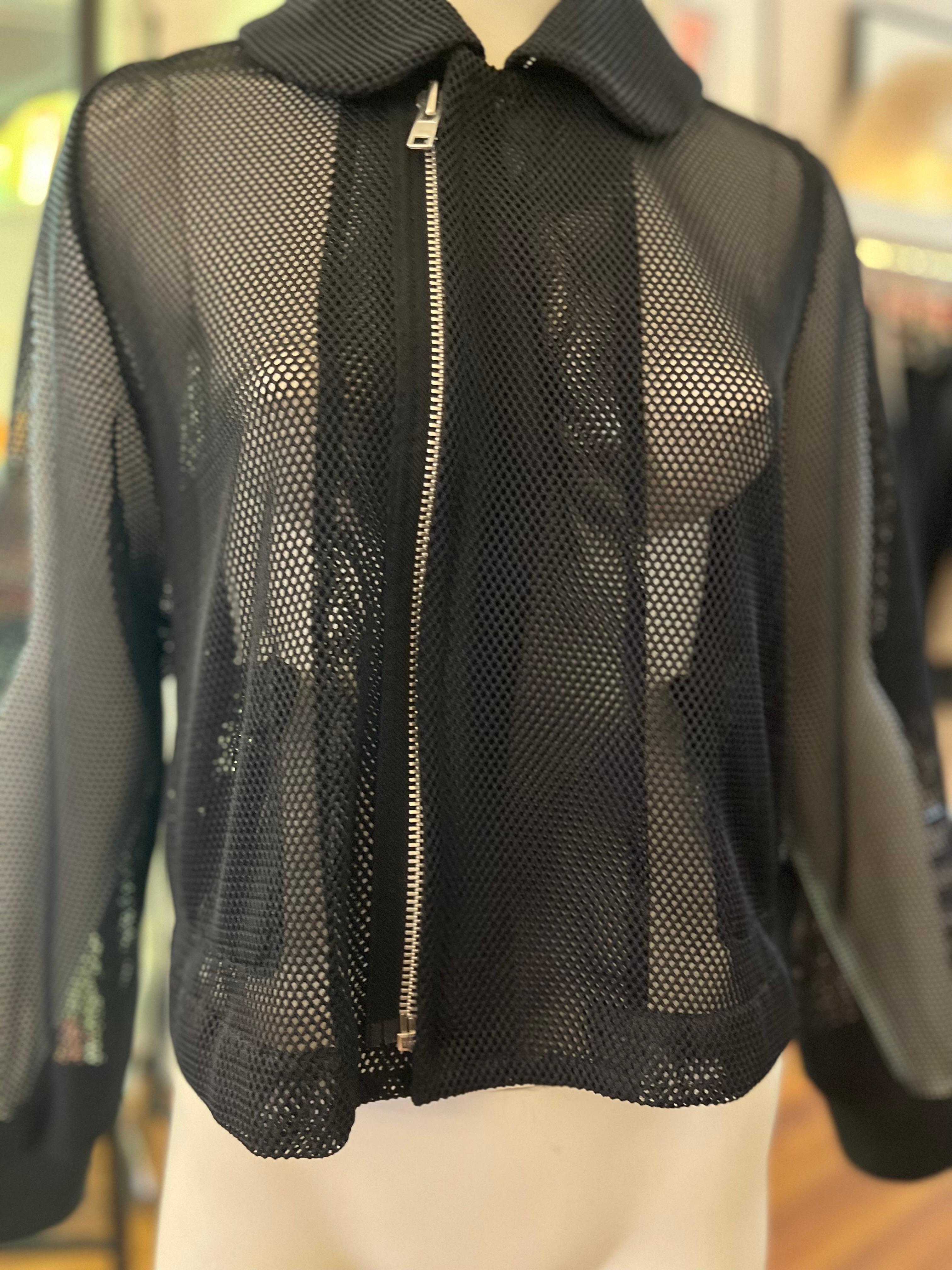 Designed by Japanese designer Rei Kawabuko, this jacket is constructed of polyester mesh with pockets on the inside. The jacket has a round collar; two adjustable half belts at the back; ribbed cuffs, and a zip at the front which is slightly off