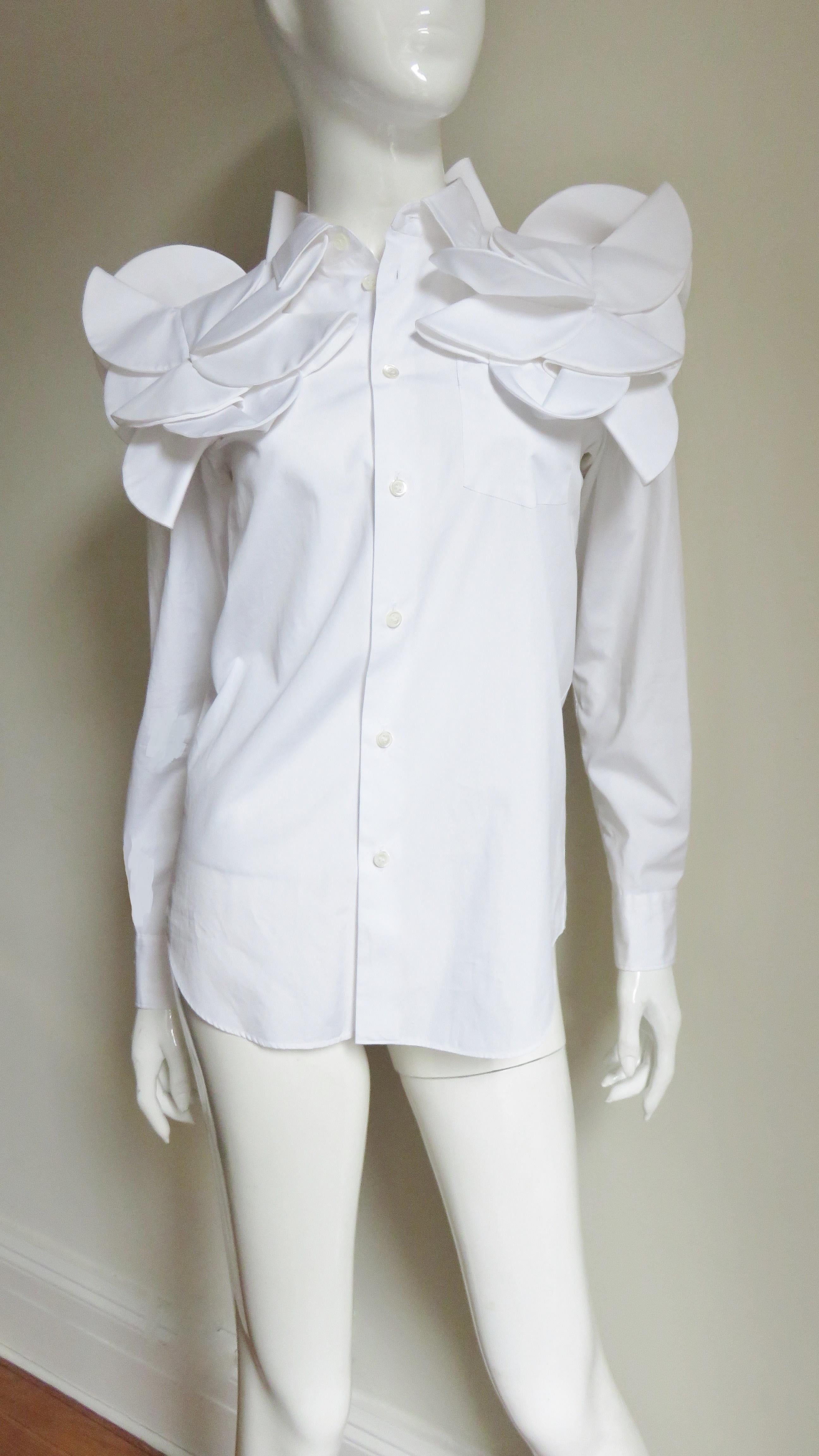 A fabulous white cotton shirt by Junya Watanabe for Comme des Garcons.  It has a shirt collar, cuffs and closes up the front with mother of pearl buttons.  Along the shoulders, upper chest and back in the same fabric are fabulous circle appliques