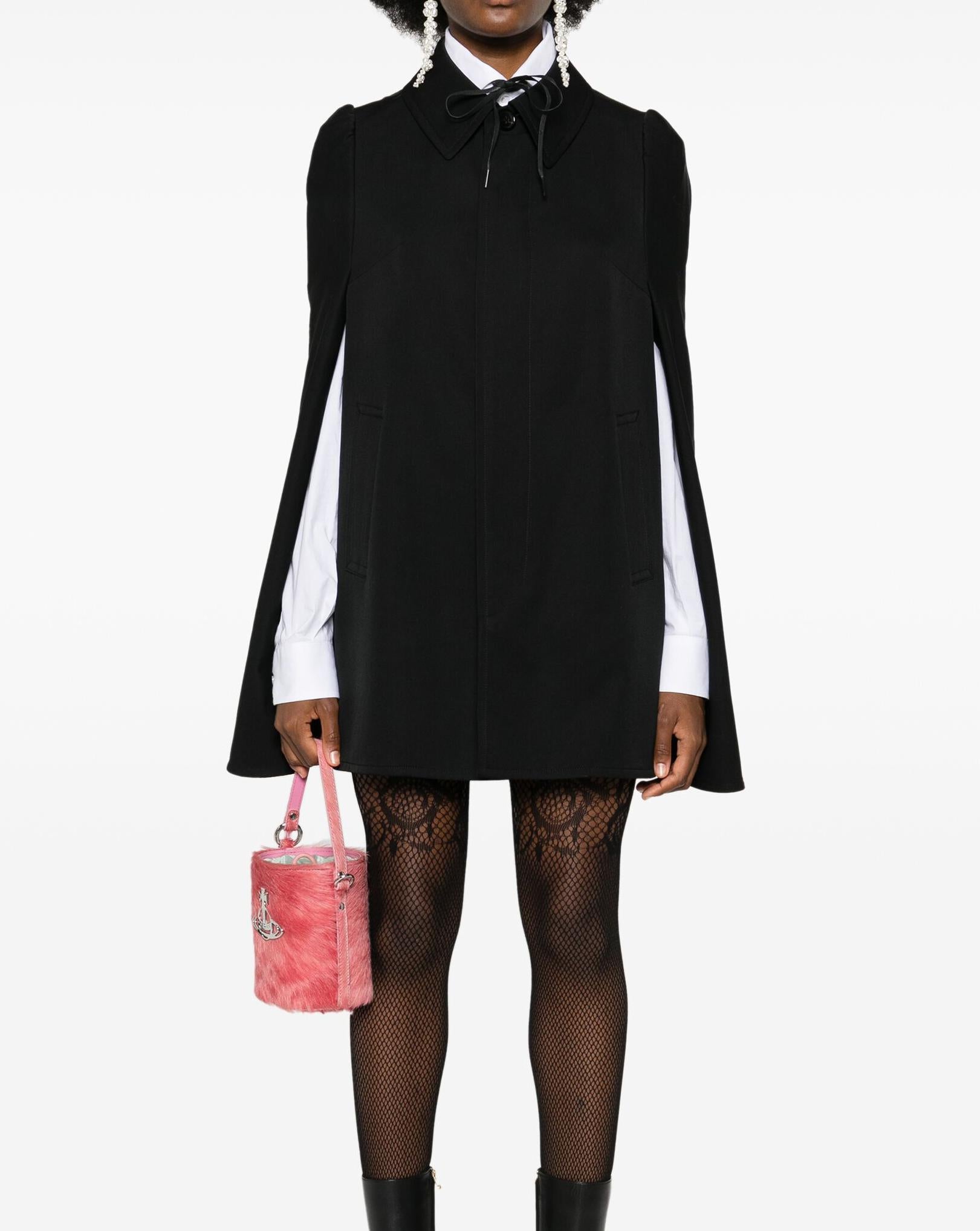 Comme des Garcons Junya Watanabe black wool cape coat featuring a cape design, straight-point collar, front tie fastening, straight hem, a front button opening, a back trench detail, front opening slit for arms and front pockets.
In good vintage