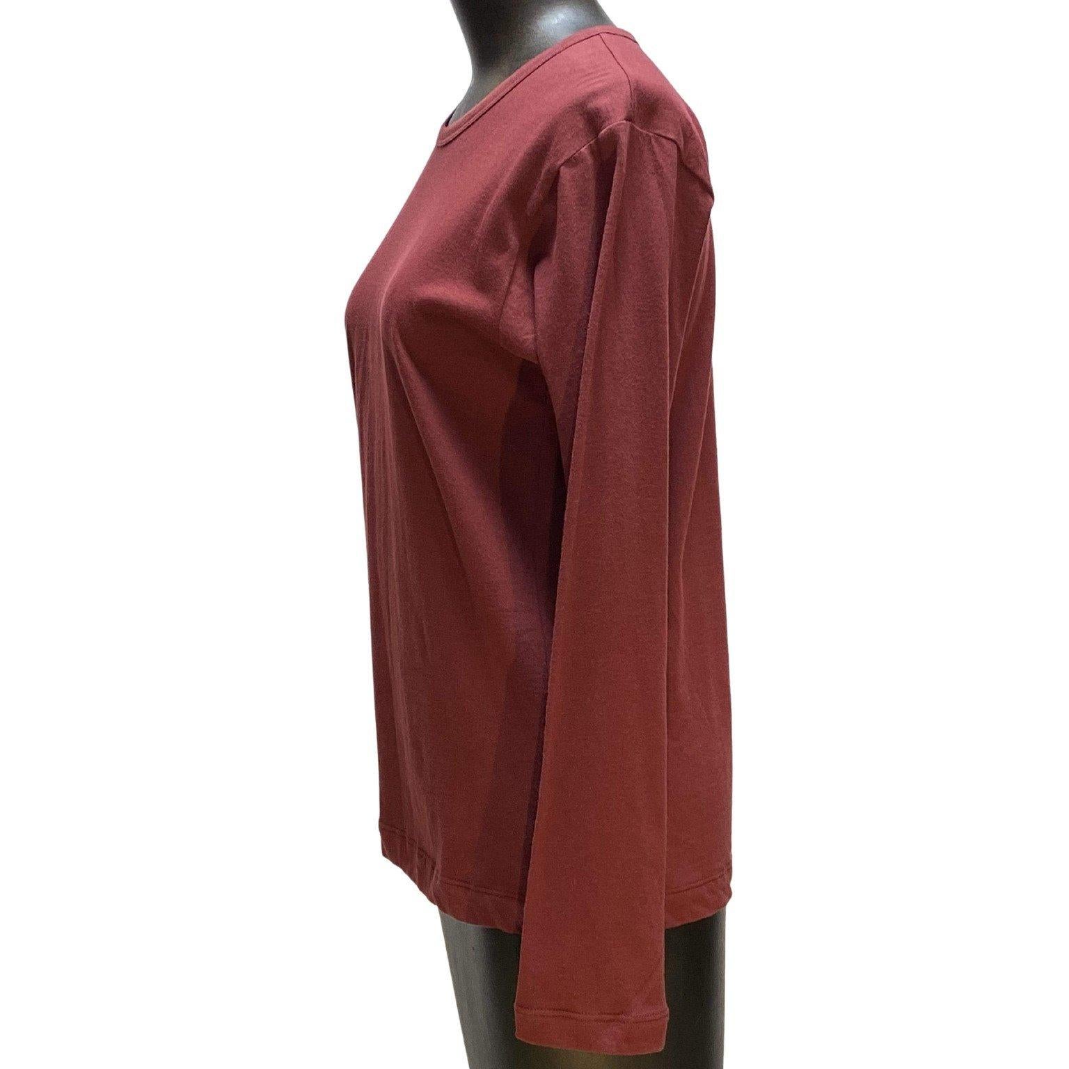 The flattering maroon color of this vintage Comme des Garçons top is not to be missed. This long sleeve top is constructed of 100% cotton and is semi-fitted.  