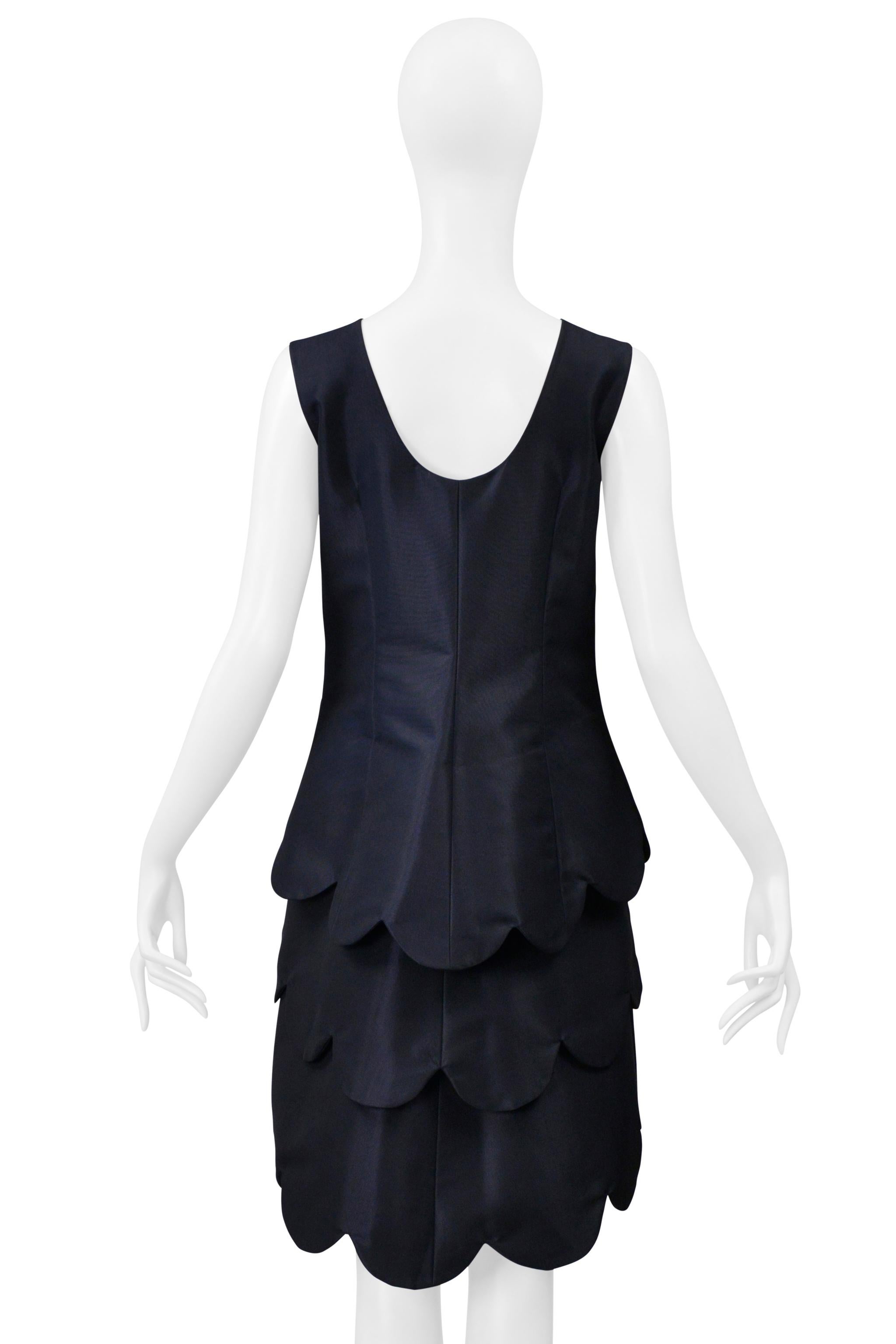 Resurrection Vintage freut sich, ein navyblaues Kleid von Comme des Garçons aus der Kollektion von 1999 präsentieren zu können. Es hat einen Rundhalsausschnitt, der eine zweite weiße Lage erkennen lässt, einen hochgeschlossenen Saum, ist ärmellos