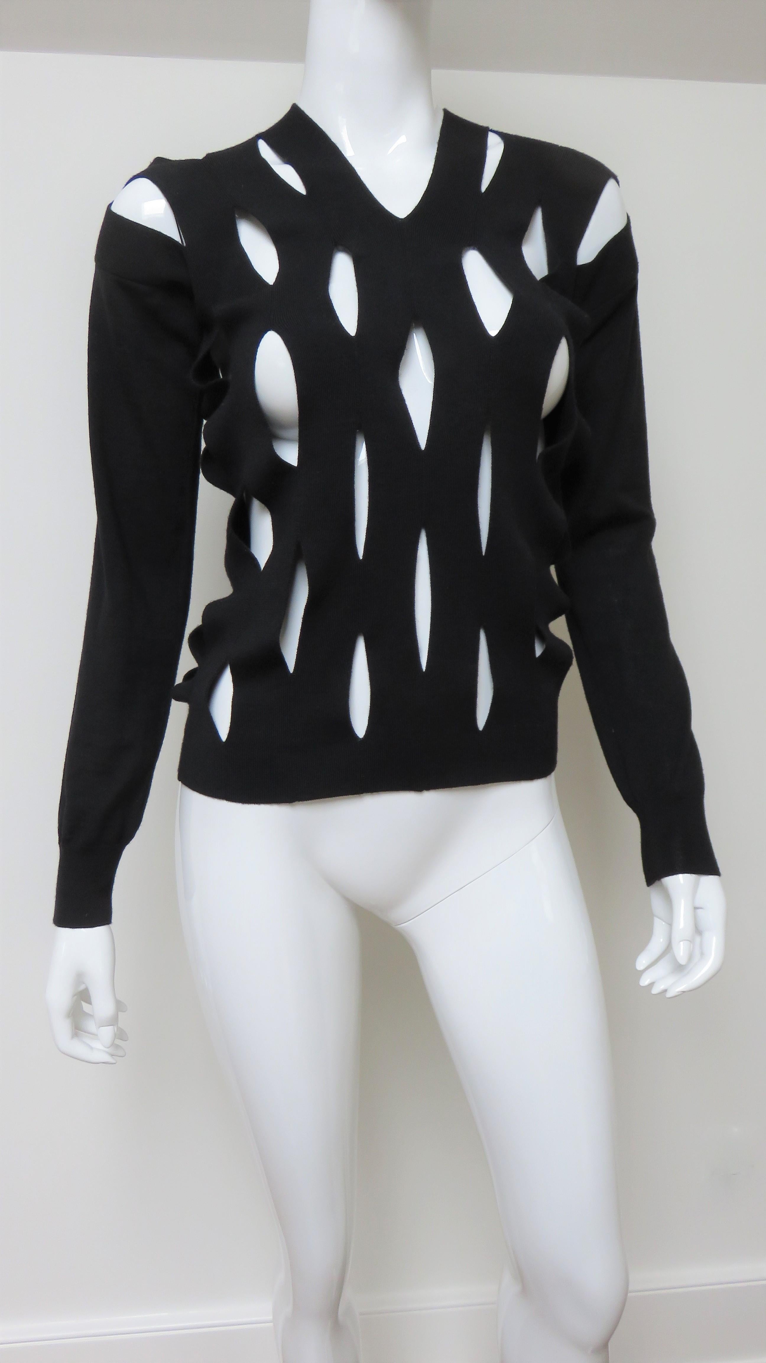 A fabulous fine knit black wool sweater with cut outs from Junya Watanabe for Comme des Garcons CDG. The V neck sweater front and back is covered in diamond shape cut outs.  The sleeves are solid with ribbed cuffs. 
Fits sizes Small, Medium.  Marked