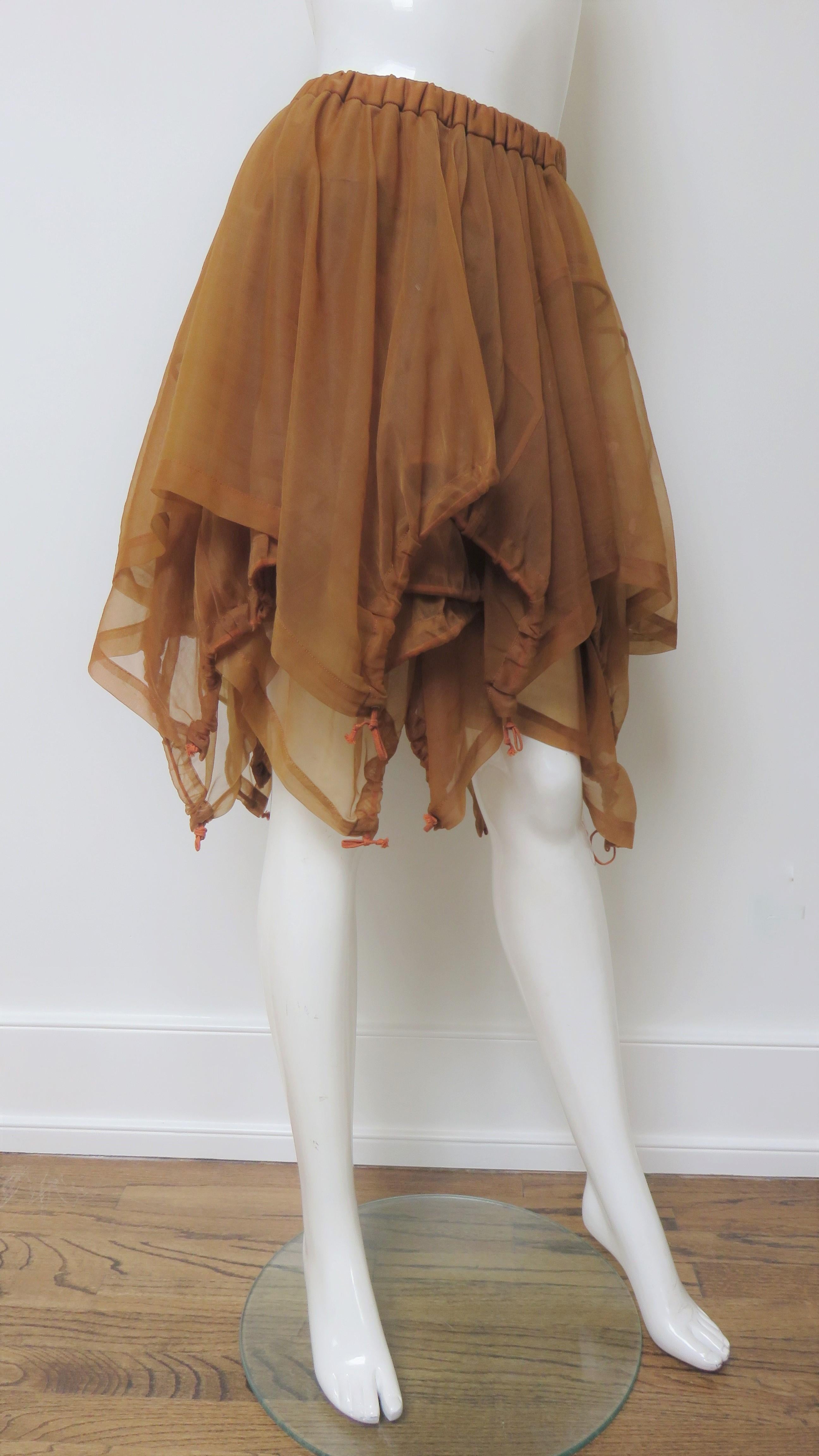 A fabulous brown parachute skirt from Comme des Garcons, CDG AD 1990 collection. The skirt is full comprised of draped, asymmetric, overlapping layers with pointed hems gathered onto a stretch waistband.  These panels have functional drawstring hems