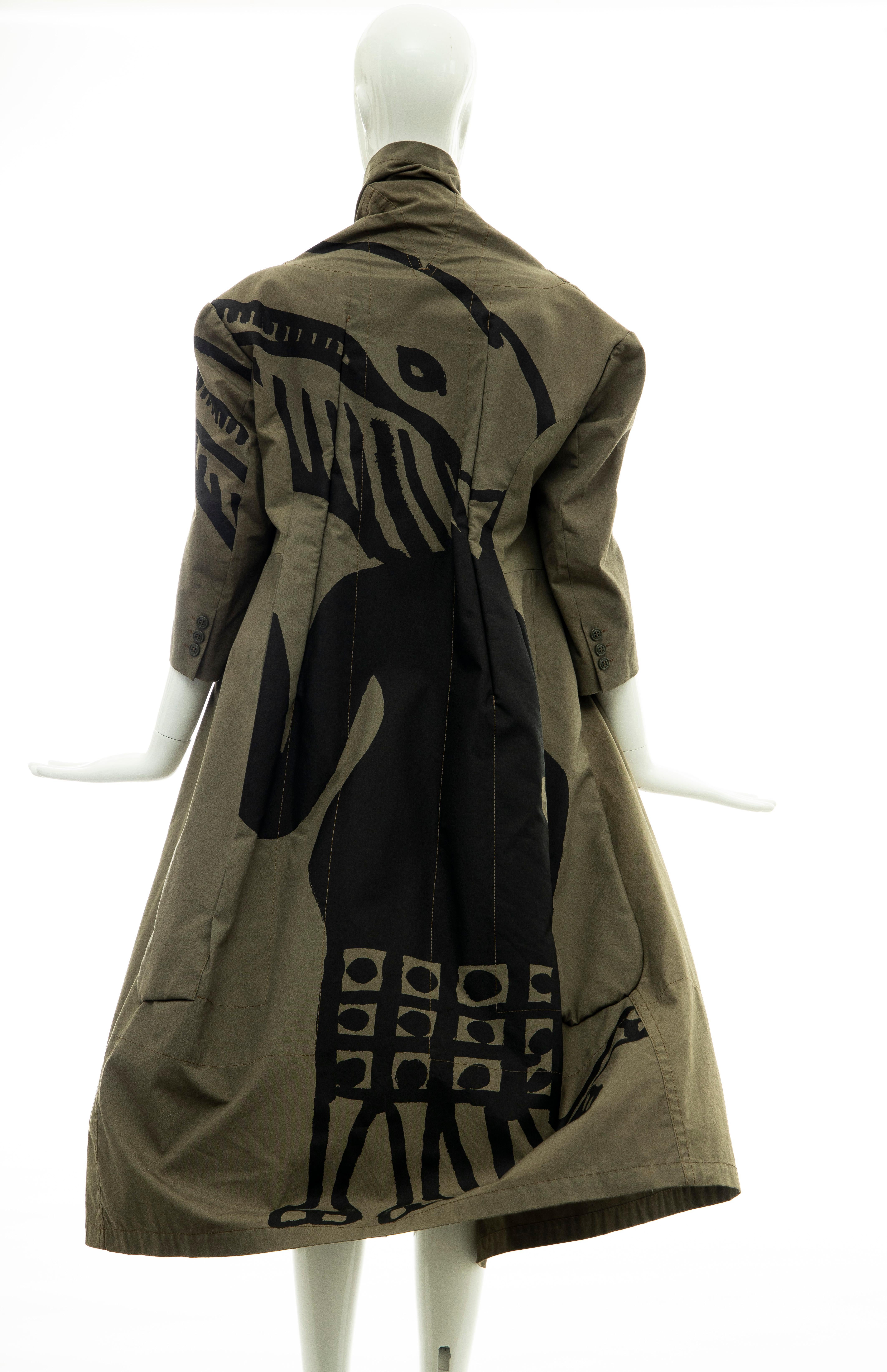 Comme des Garçons Runway (Look 8) Fall 2009, olive green coat with graphic print at back, three-quarter length sleeves, brown seamed faux pockets, padded lapels, olive brown and olive green patchwork deconstructed interior, dual interior pockets and