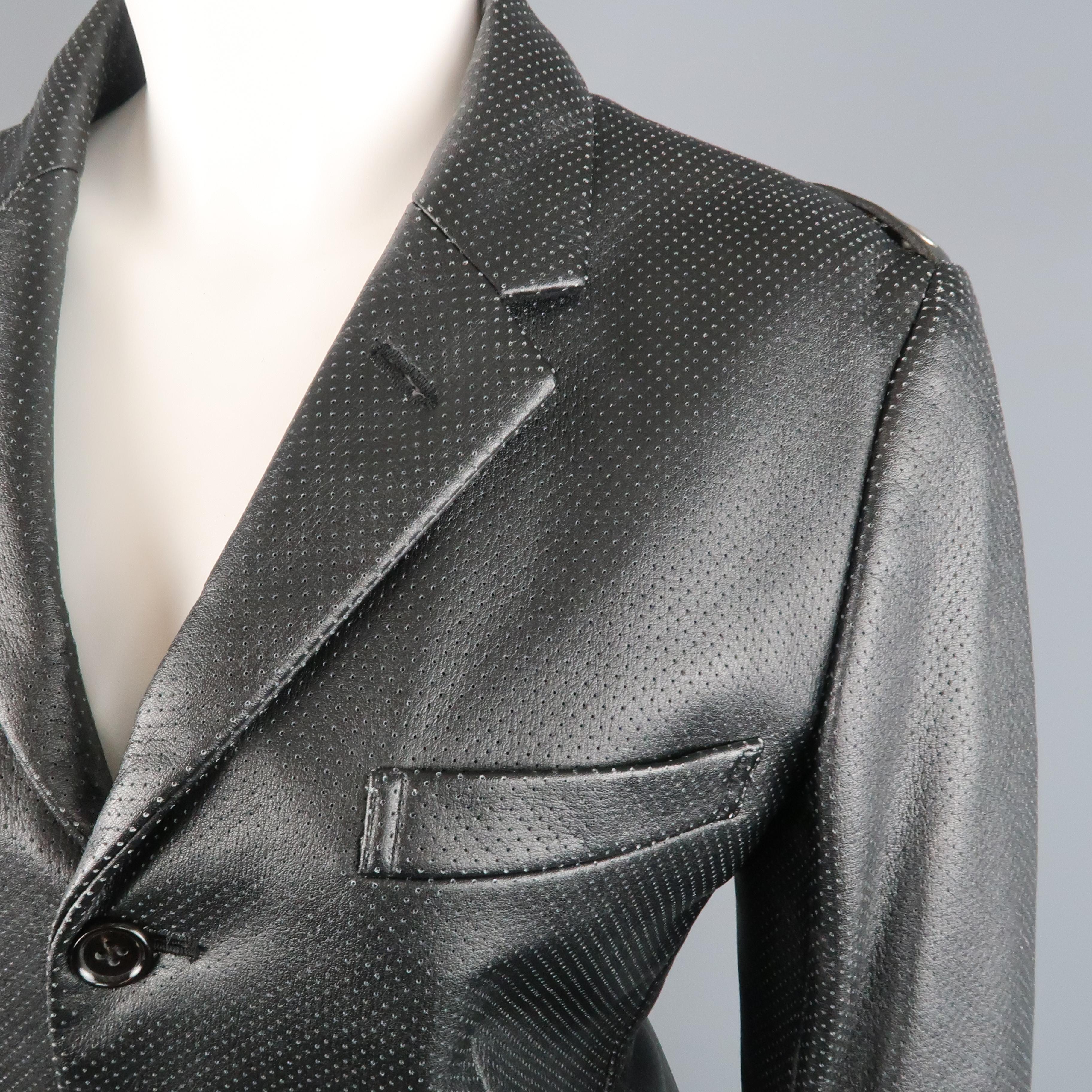 COMME des GARCONS blazer comes in perforated vegan faux leather with a notch lapel, three button, single breasted front, flap pockets, and grommet belt back detail along the shoulders. Made in Japan.
 
Excellent Pre-Owned Condition.
Marked: S 