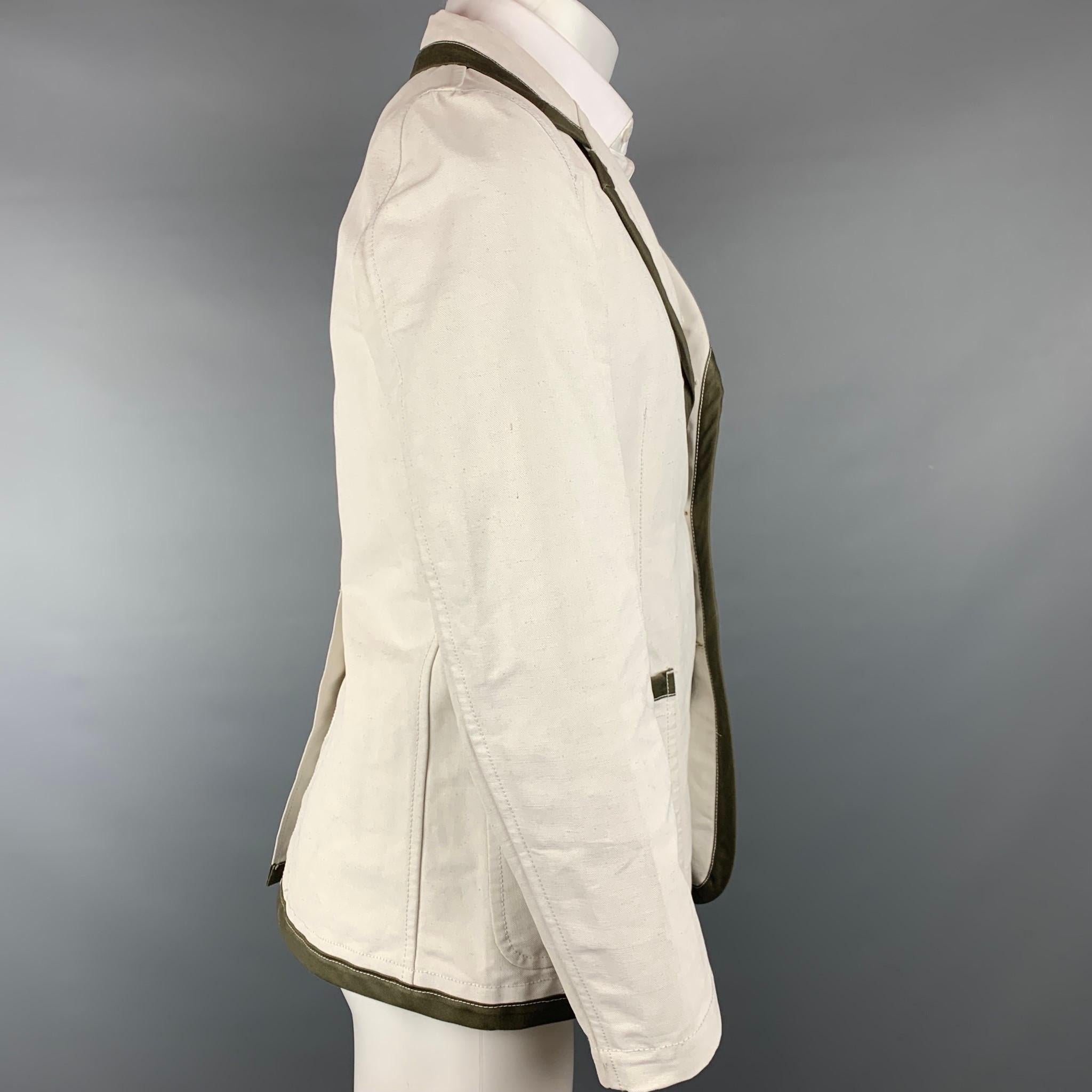 COMME des GARCONS sport coat comes in a off white linen / cotton with a olive trim featuring a notch lapel, patch pockets, and a three button closure. Made in France. 

Very Good Pre-Owned Condition.
Marked: M

Measurements:

Shoulder: 16.5