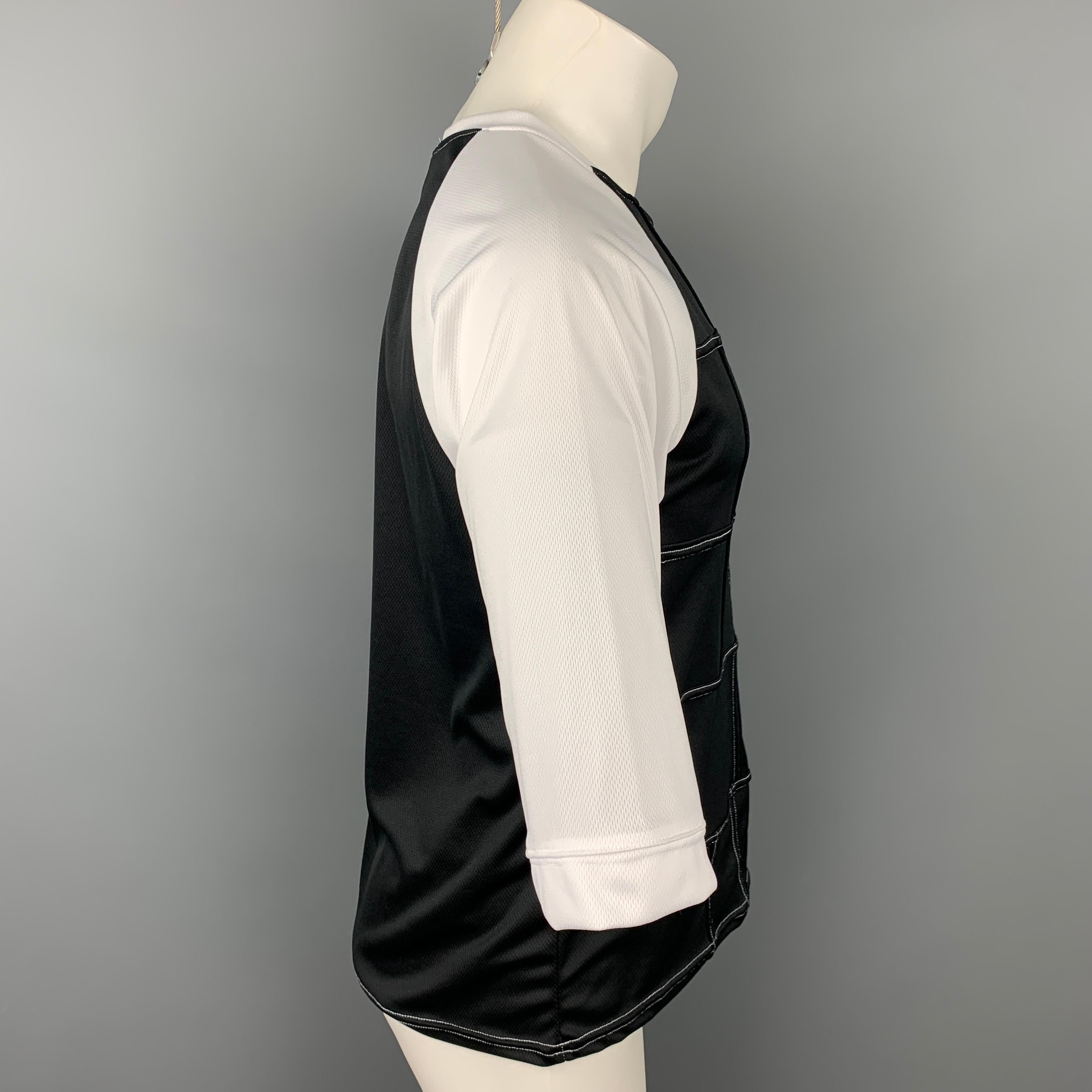 COMME des GARCONS BLACK t-shirt comes in a black & white two toned polyester featuring raglan sleeves and a crew-neck. Made in Japan.

Very Good Pre-Owned Condition.
Marked: XL

Measurements:

Shoulder: 16.5 in.
Chest: 40 in.
Sleeve: 16 in.
Length:
