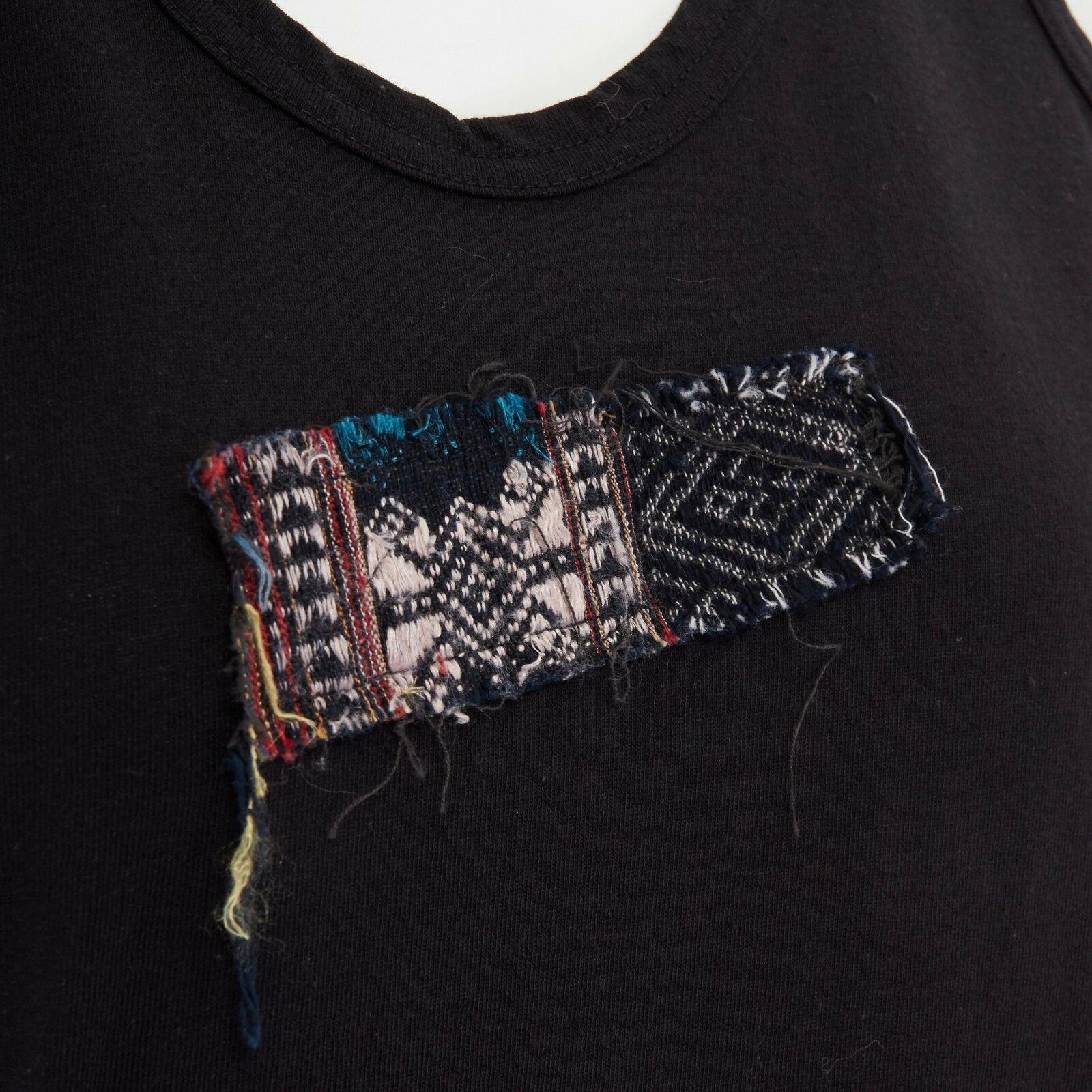 COMME DES GARCONS SS1992 black cotton ethnic raw patch vest tank top S 
AS PART OF SPRING SUMMER 1992
Brand: COMME DES GARCONS
Material: Cotton
Color: Black
Extra Details: Black cotton. Multicolor ethnic embroidered raw edge patch detail at front.