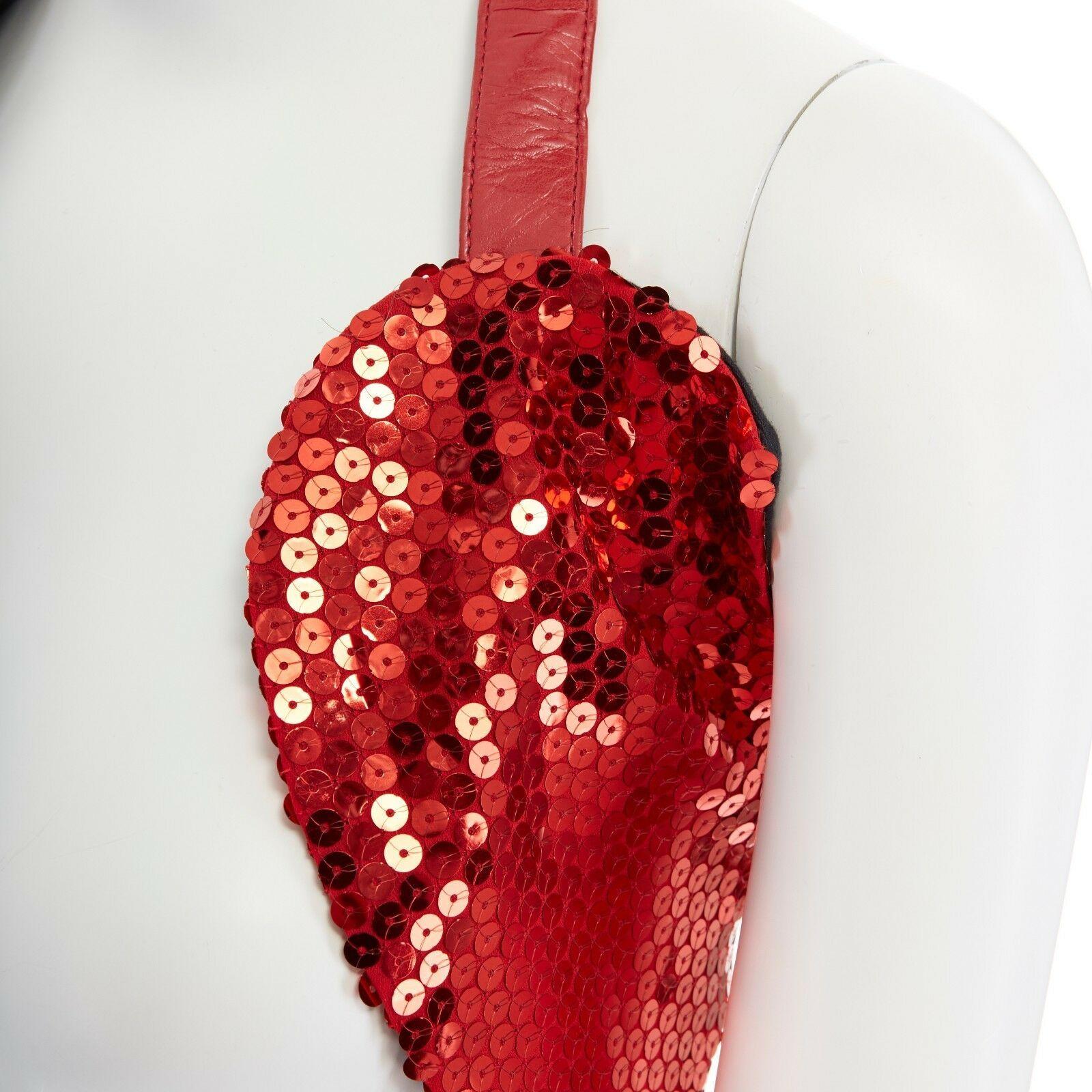 COMME DES GARCONS SS2010 red sequins faux leather dual wrap harness vest top XS

COMME DES GARCONS
FROM THE SPRING SUMMER 2010 COLLECTION
Red sequins embellished. Faux leather wrap-around belt. Silver-tone buckle closure. 
Made in
