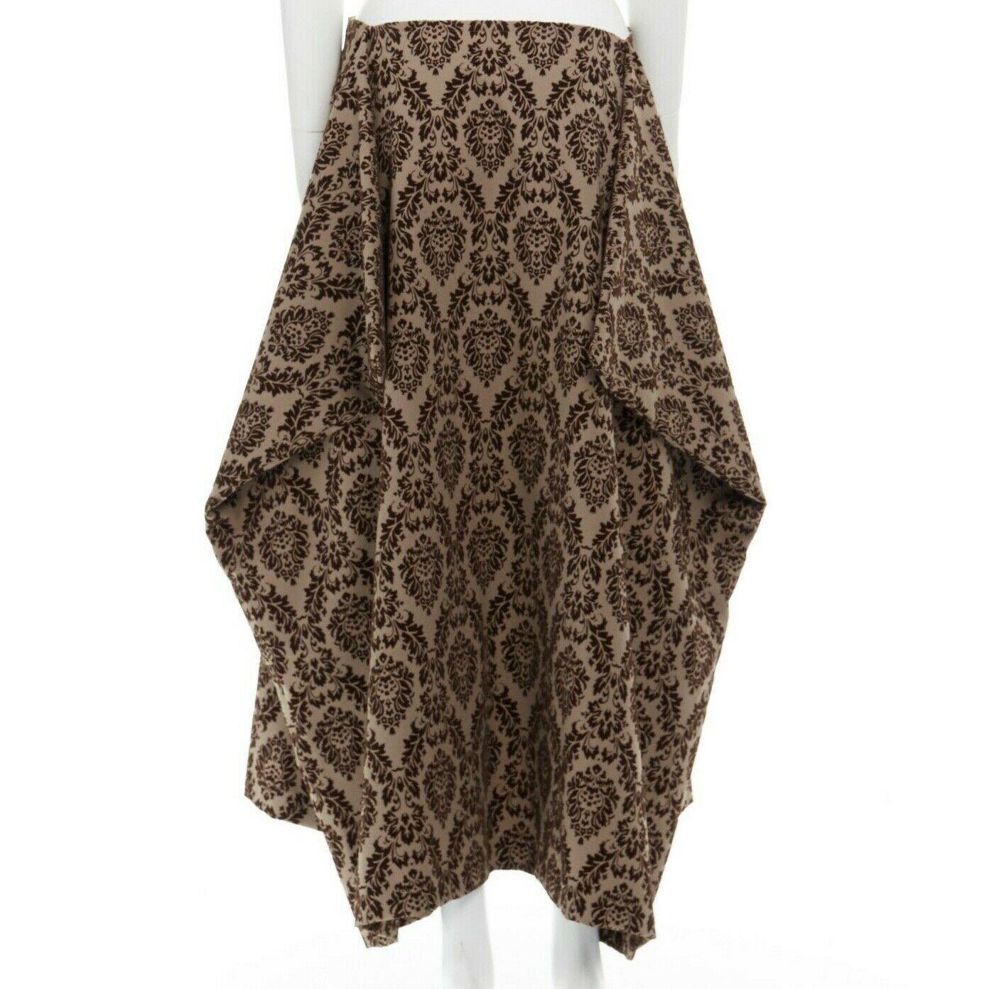 COMME DES GARCONS Vintage AW1996 brown damask devore velvet wing volume skirt S
COMME DES GARCONS by REI KAWAKUBO
FROM THE AD1996 COLLECTION
Polyester. Taupe brown. 
Dark brown damask flocked velvet devore pattern. 
Winged side volume. Concealed