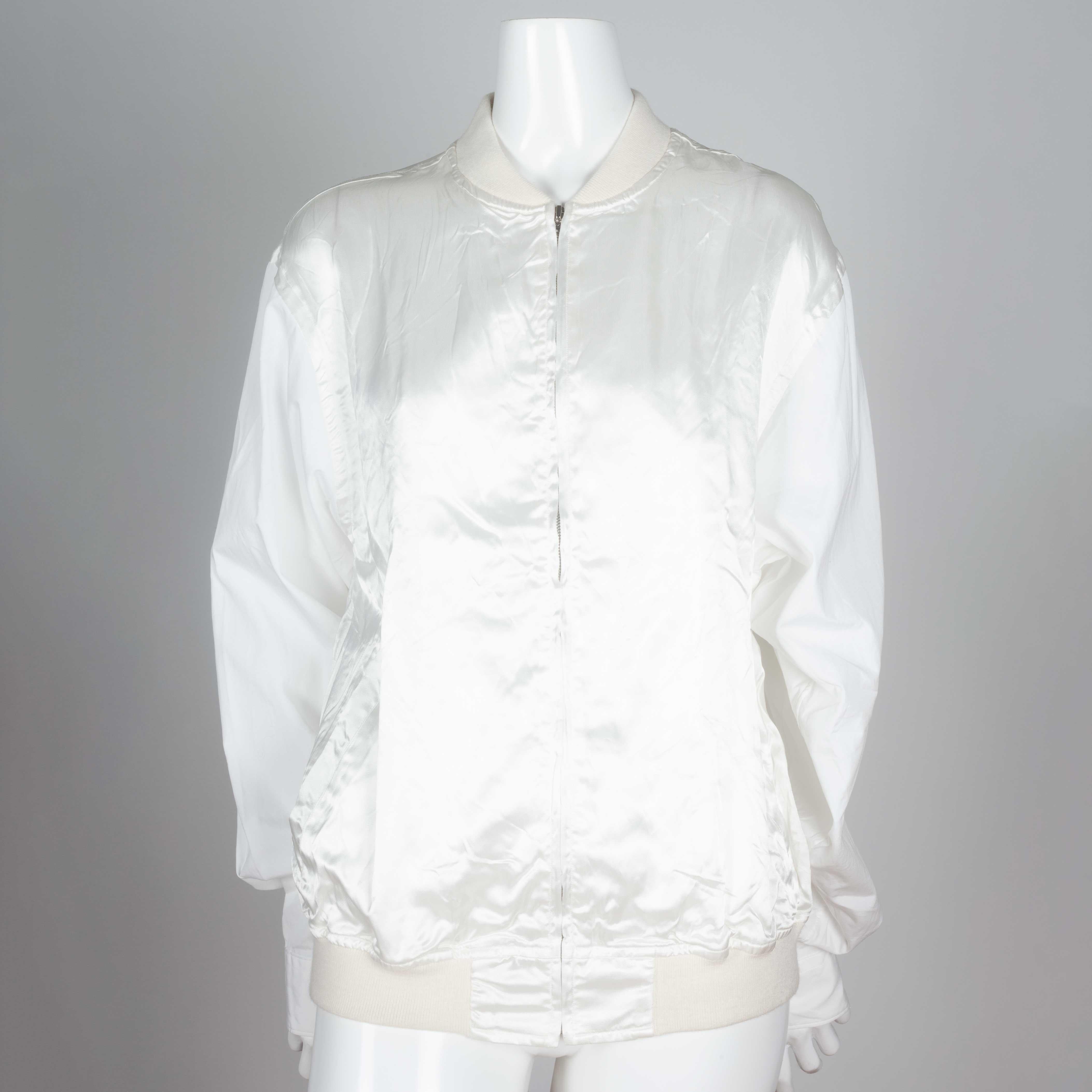 Comme des Garçons white and off-white bomber style shirt from Japan with slinky rayon torso, cotton shirt sleeves and cotton ribbing. A unique combo of jacket, dress shirt and blouse. 

YEAR: Unknown
MARKED SIZE: M
US WOMEN'S: M/L
US MEN'S: S/M
FIT: