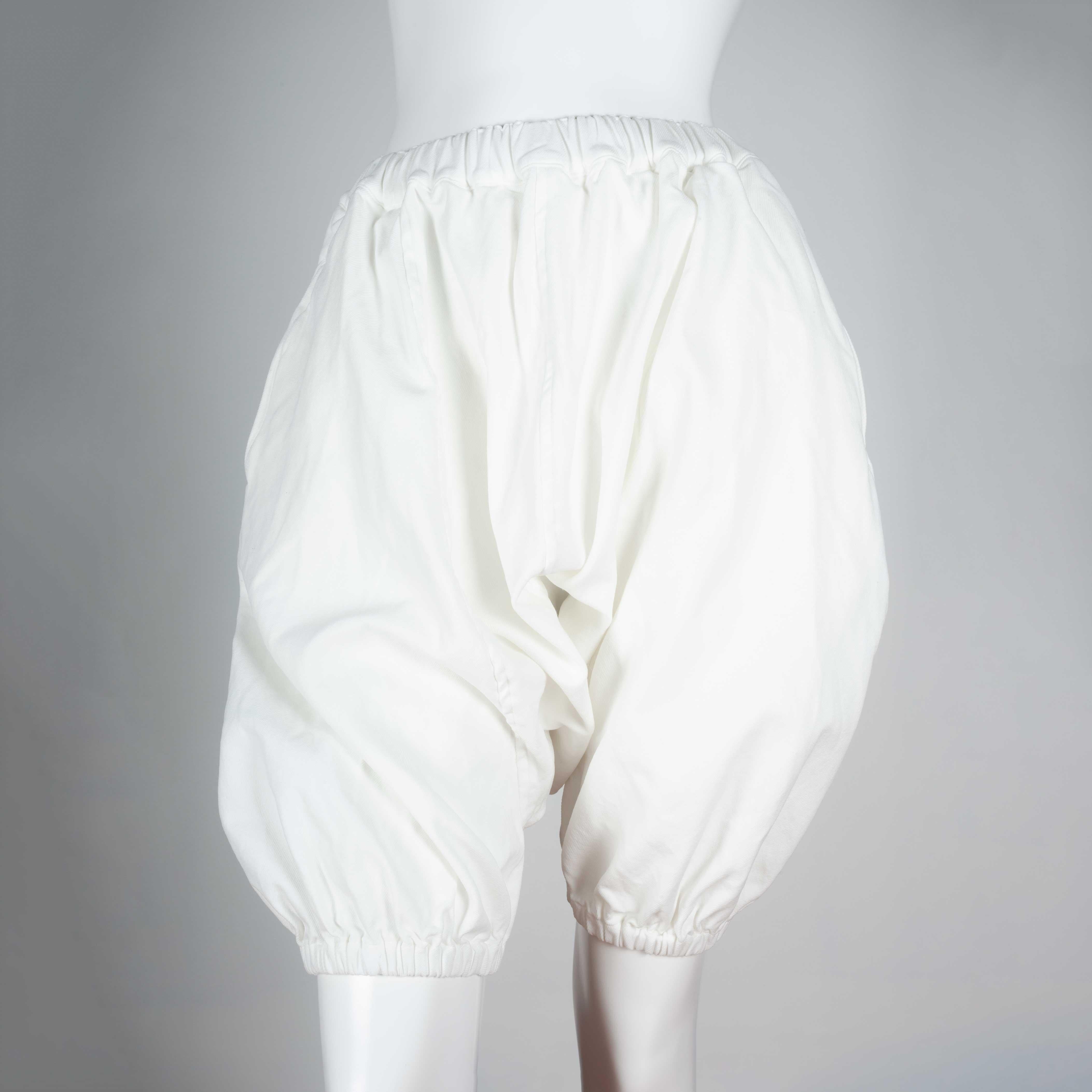 Comme des Garçons 2010 white harem pants with elastic waist and hem. Ballooning, voluminous fabric gives these pants easy comfort and a singular silhouette. 

YEAR: 2010
MARKED SIZE: XS
US WOMEN'S: XXS
FIT: Regular
WAIST: 11