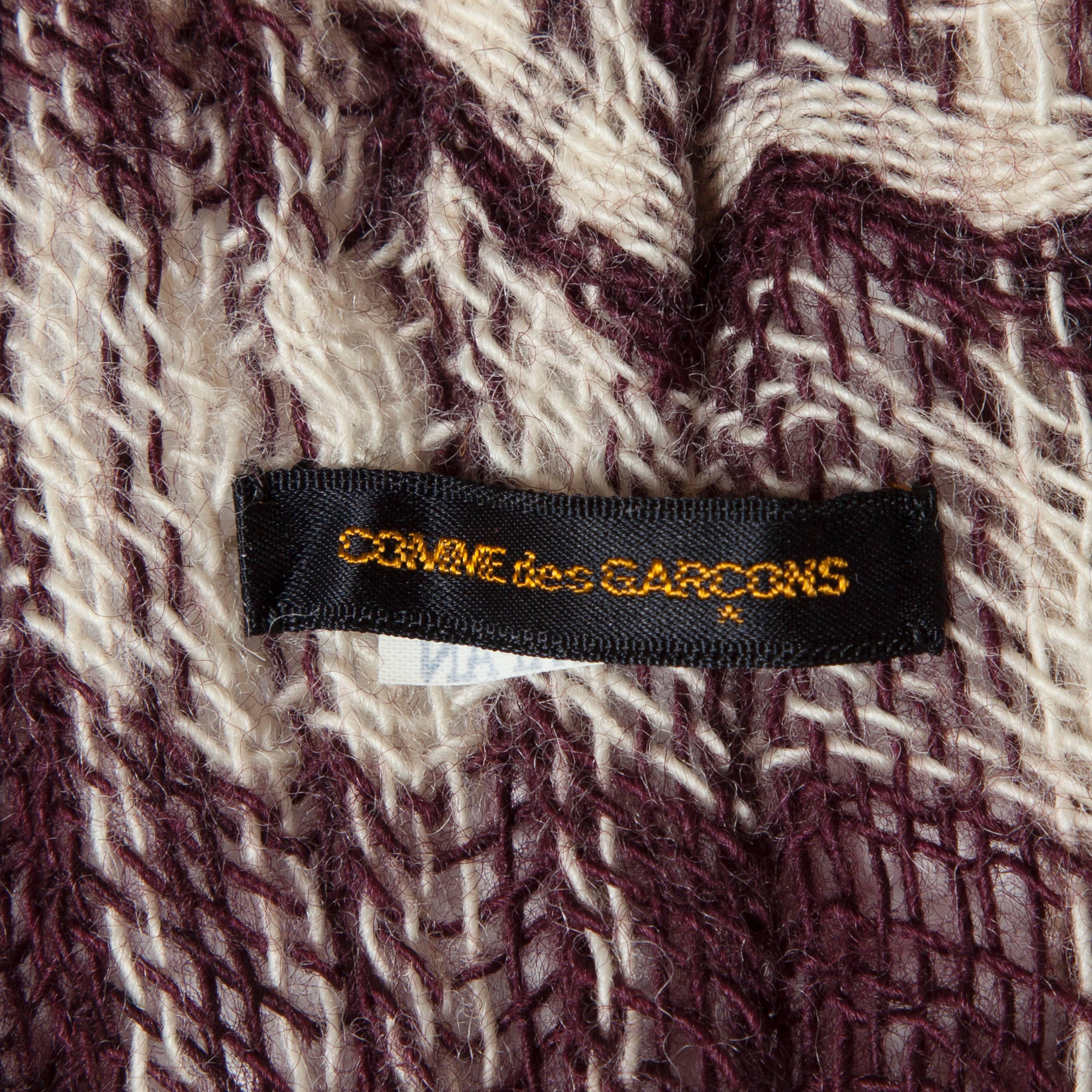 Comme des Garcons knit woven over sized scarf from 1983.
Plaid like pattern with bordeaux and cream white wool yarn carefully woven material with such calculated detail. Great archive piece.
The same scarf was used in book 