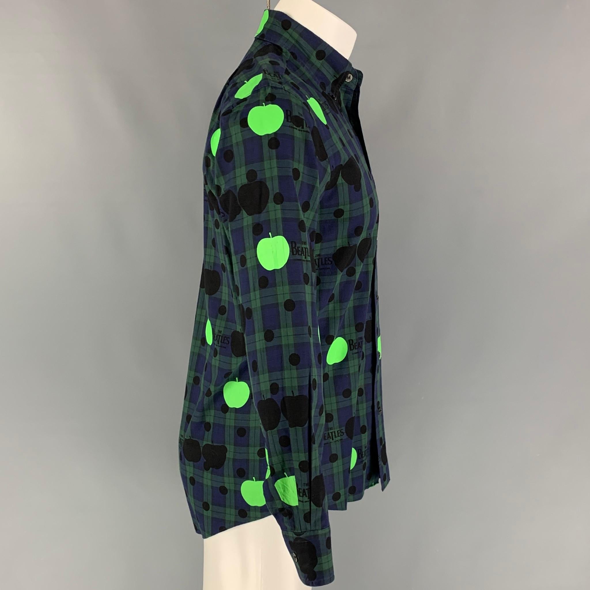 COMME des GARCONS x The Beatles long sleeve shirt comes in a navy & green plaid material with graphic details featuring a button down collar, front pocket, and a button up closure. Made in Japan. 

Very Good Pre-Owned Condition.
Marked: M
Original