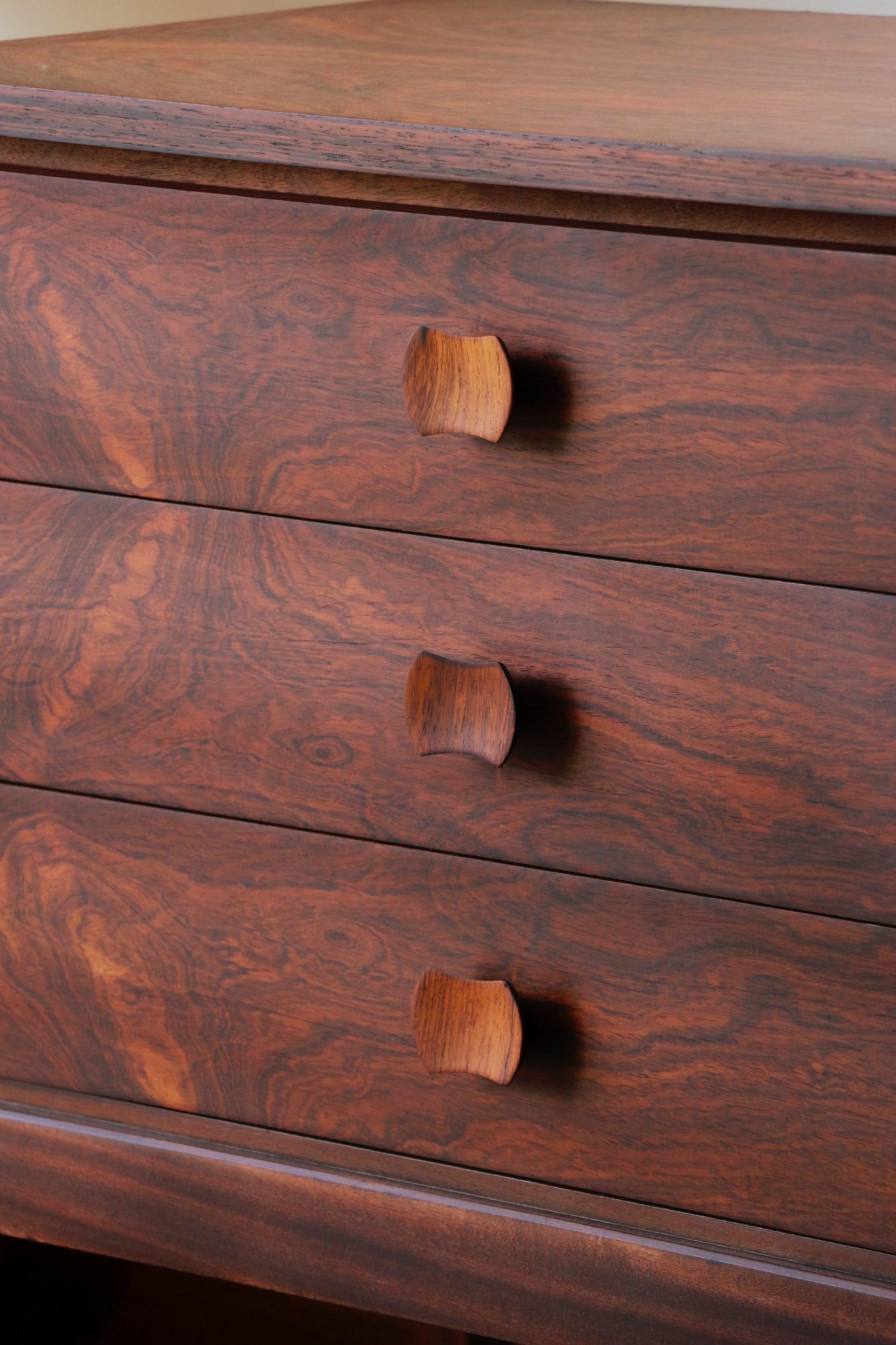 Magnifique commode 6 tiroirs en palissandre datant des années 60.

Son sublime veinage lui donne un charme certain et son format pratique lui permet de se glisser partout.
Le coulissement des tiroirs se fait parfaitement.
La couleur est brun foncé