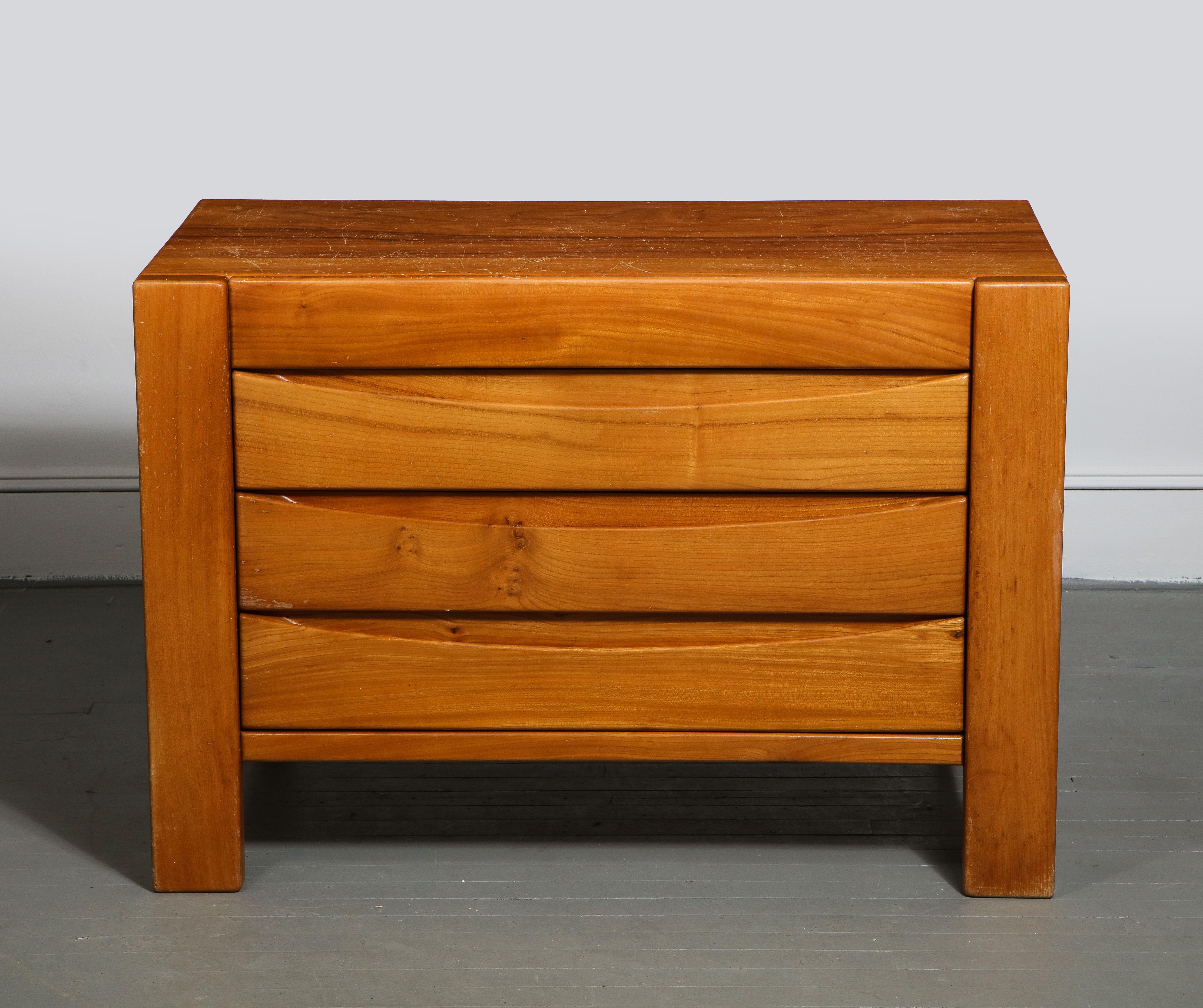 Elm commode by Maison Regain, France, c. 1970s. 

This modest yet sophisticated commode consists of a study elm construction, plank legs, and three drawers with handsome dovetail joints -- all quintessential trademarks of Maison Regain's late 20th