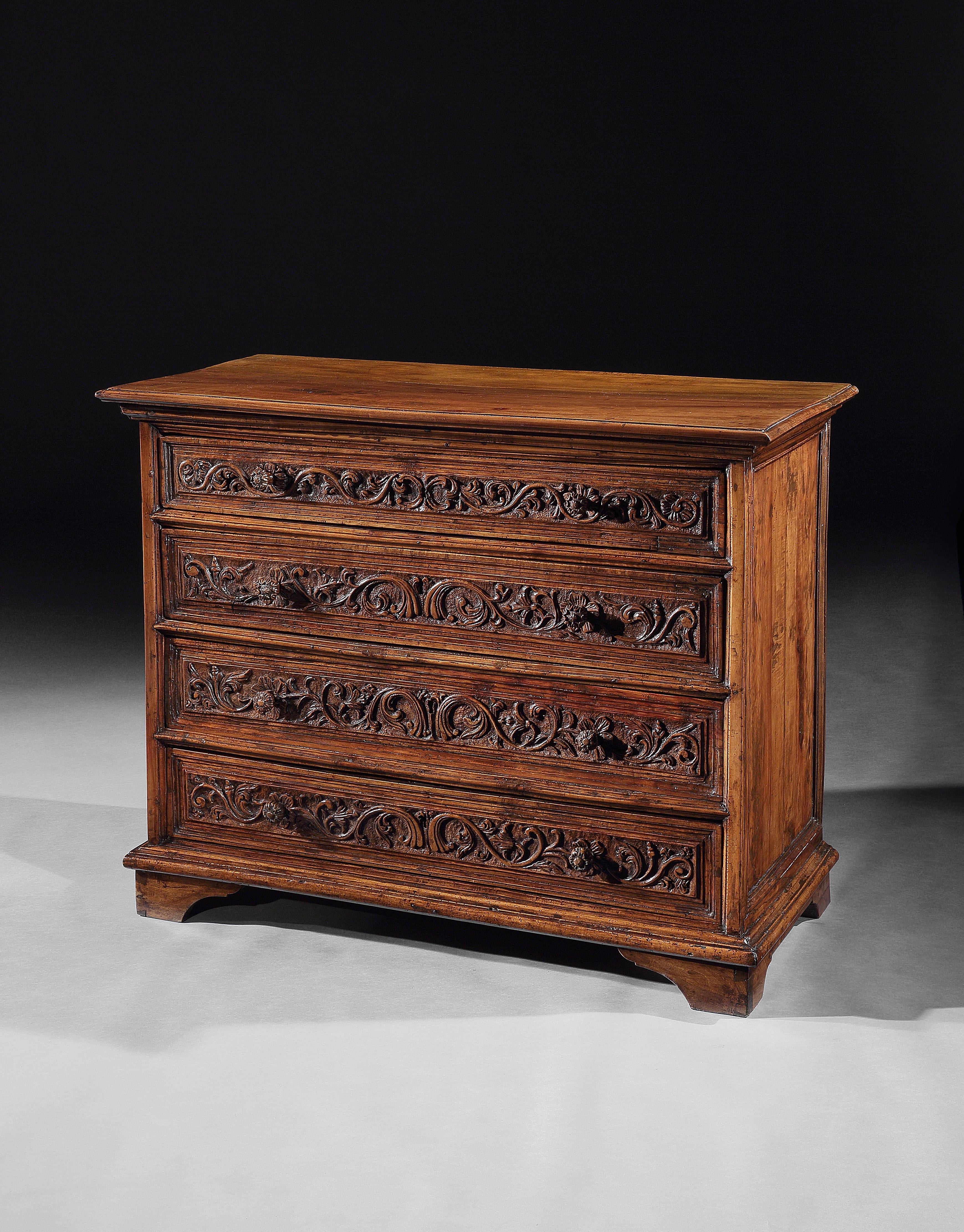 This rare cassettone oozes charm and character. The carved decoration is particular to Brescia in Lombardy and the knobs are a rare feature carved as flowerheads to the petals behind so that they become part of and blend into the carved decoration