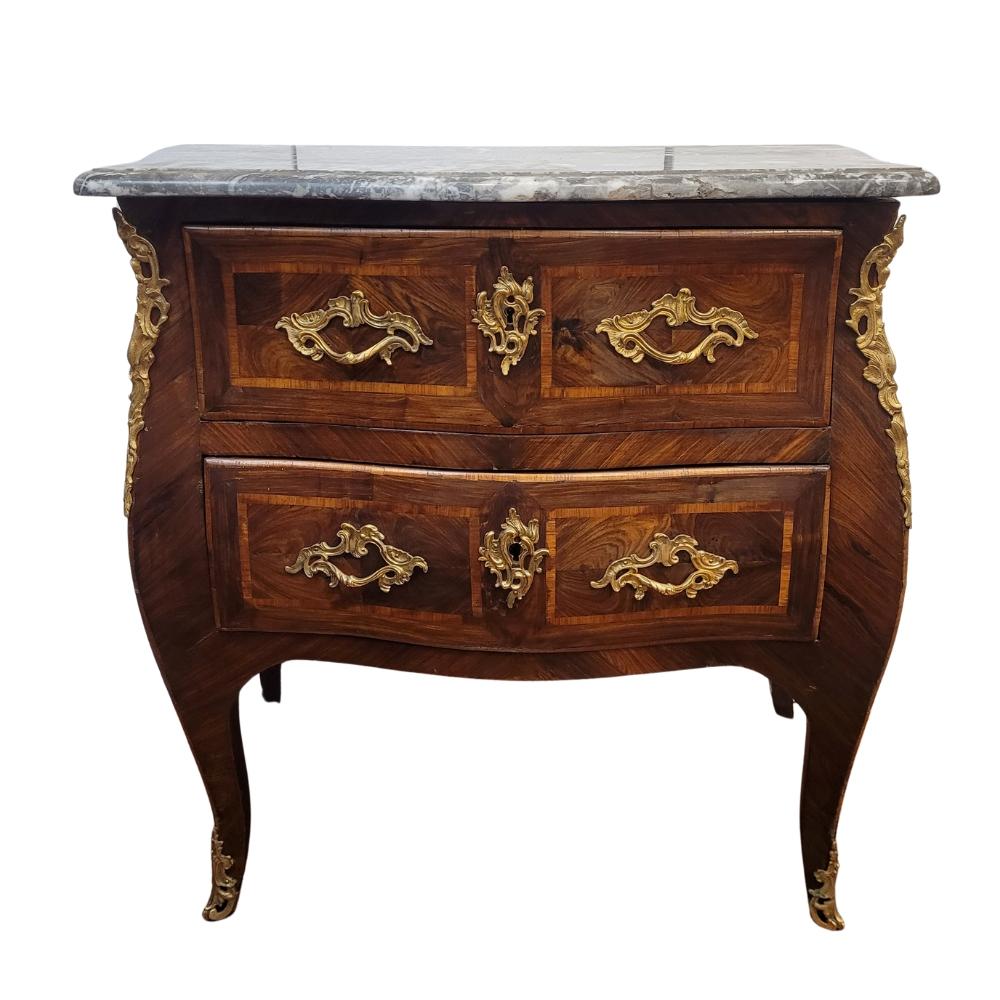 One of a kind and wonderful 18th-century Louis XV transitional style chest with a curved design and delicate marquetry motifs. It features two front registers, each displaying finely crafted precious wood marquetry that adds a touch of luminosity to