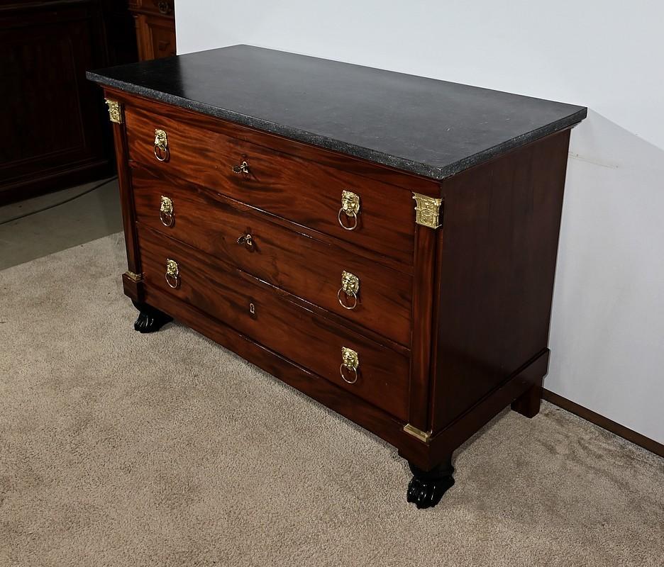 Commode en placage d'acajou munie de trois tiroirs identiques se tirant à l'aide d'anneaux avec mufle de Lion. Le coulissage des tiroirs est parfait. Ceux-ci possèdent une traverse intermédiaire et ont un fond en chêne.  Au centre, chaque tiroir