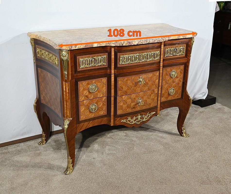 Bellissima cassettiera a tre cassetti in legno di palissandro e impiallacciatura di amaranto, sormontata da marmo Brocatelle.
Il primo di questi cassetti, nella parte superiore, presenta un frontale rialzato, intarsiato in palissandro e riccamente