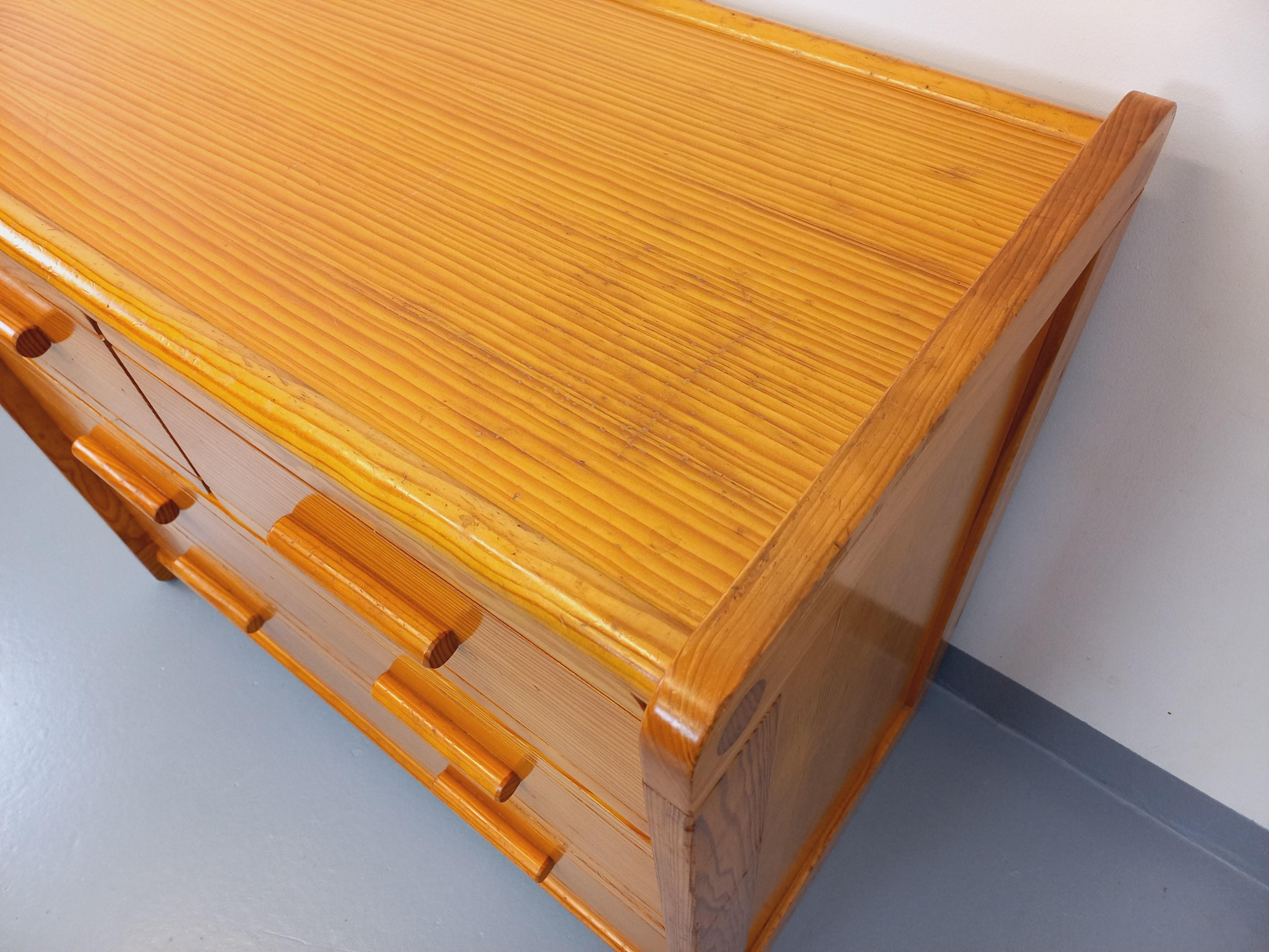 Commode vintage degli anni 70 80, attribuito al marchio Gautier, in bois de pin, 4 tiriirs: 2 grands et 2 plus petits, joli travail des poignées et des détails d'assemblage, intérieurs des tiroirs en mélaminé, bon état général avec des signs et