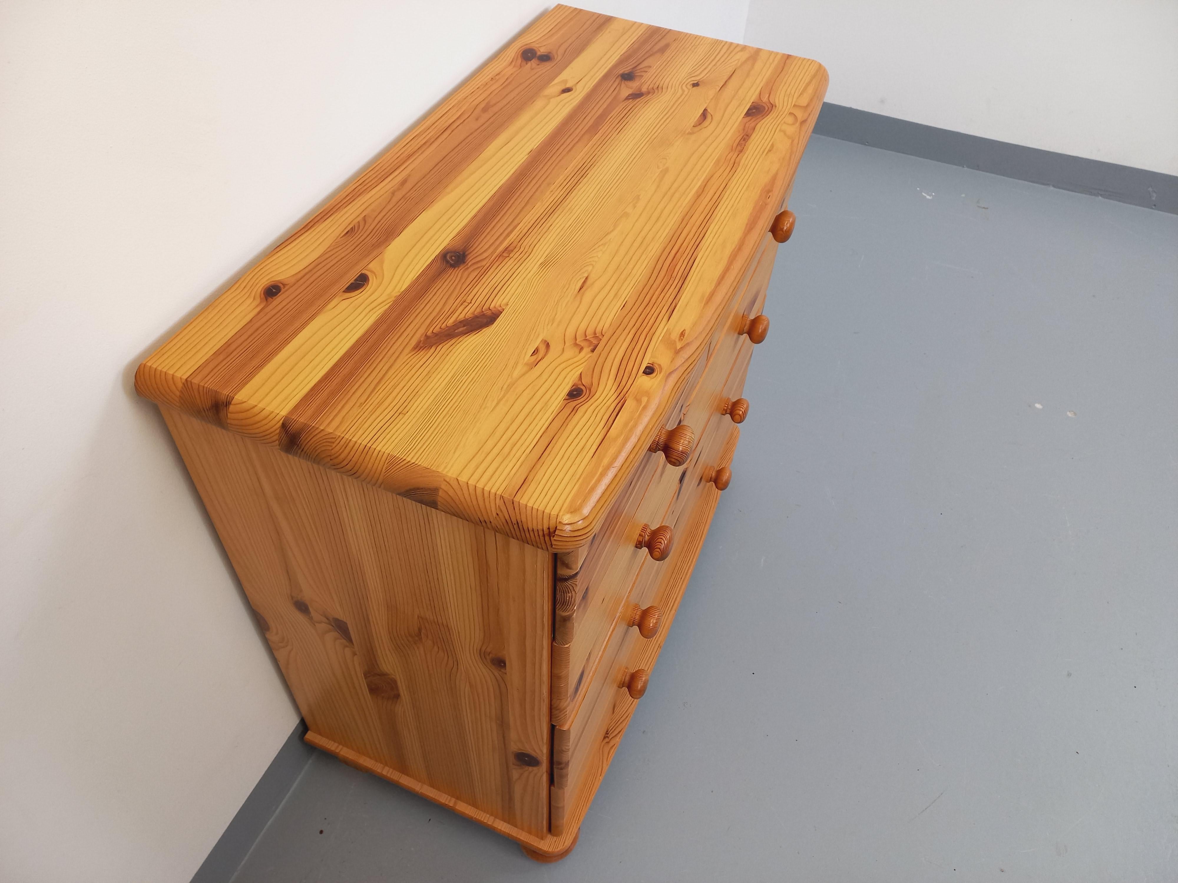 Commode vintage degli anni 70, en bois de pin, 5 tiriirs, 3 grands et 2 petits, très jolis pieds boules et plateau incurvé, très bon état général avec quelques signes du temps qui passe (quelques rayures et marques d'usage et de surface,