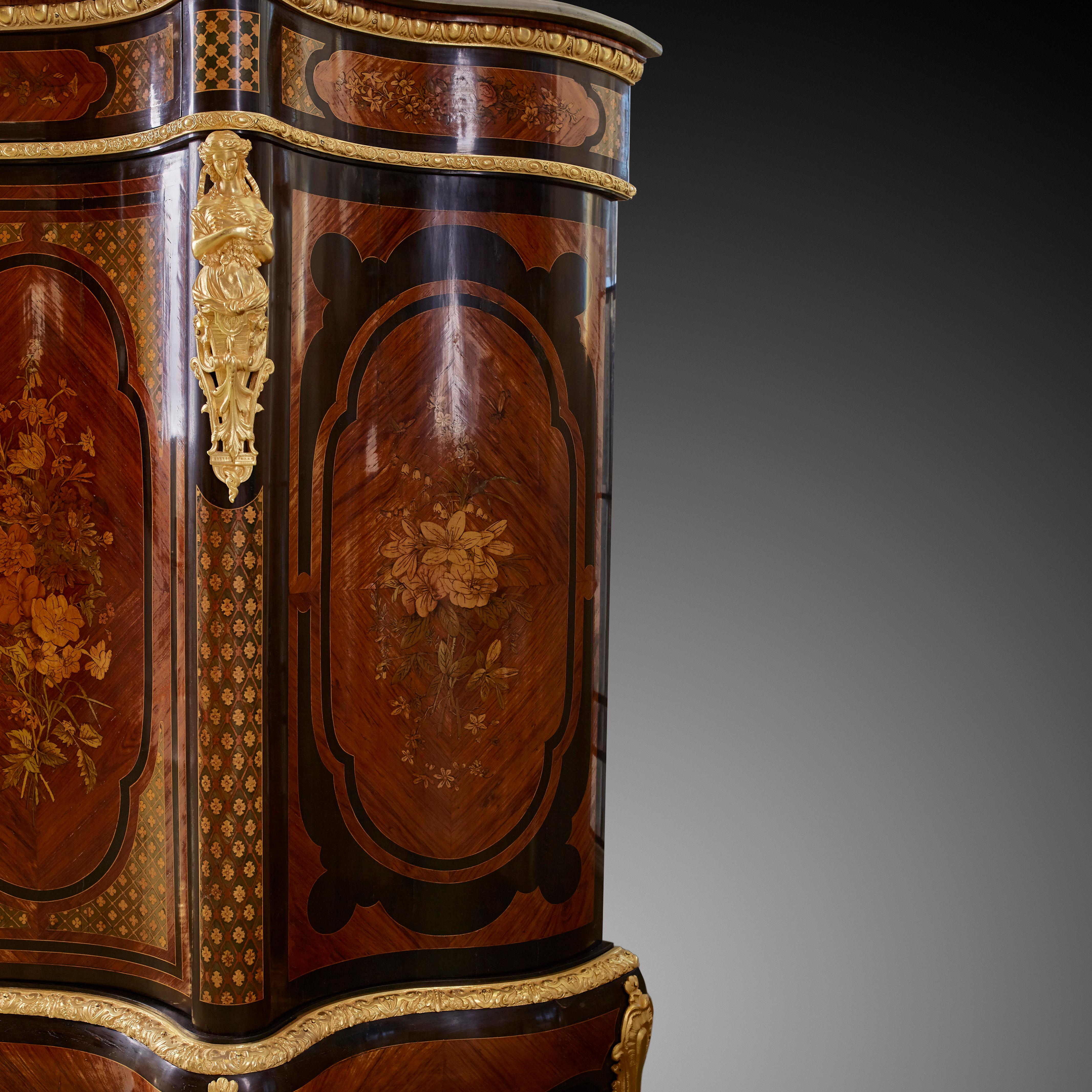 Alexander Roux Serpentine Inlaid Side Cabinet’ uses mainly light wood materials such as kingwood or satinwood, and floral motifs to bring a feeling of closeness, friendliness towards nature. The background texture has a classic trellis lattice