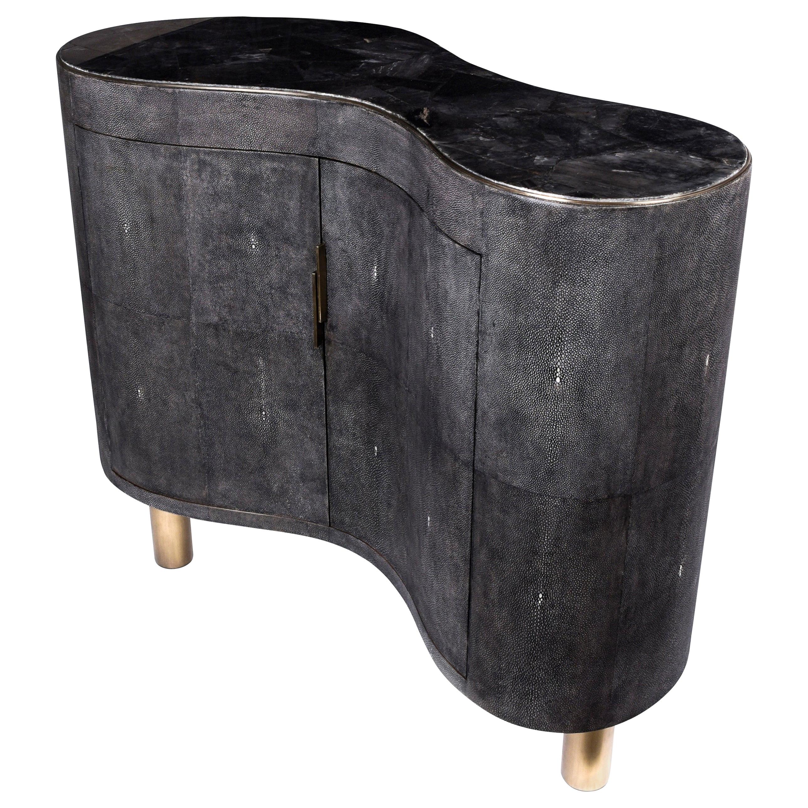 The constellation commode is the perfect storage unit for a living room or dining area. The amorphous shaped piece is completely inlaid in cream shagreen, with a stunning Smokey white quartz top. The piece sits on a pair of tubular bronze-patina