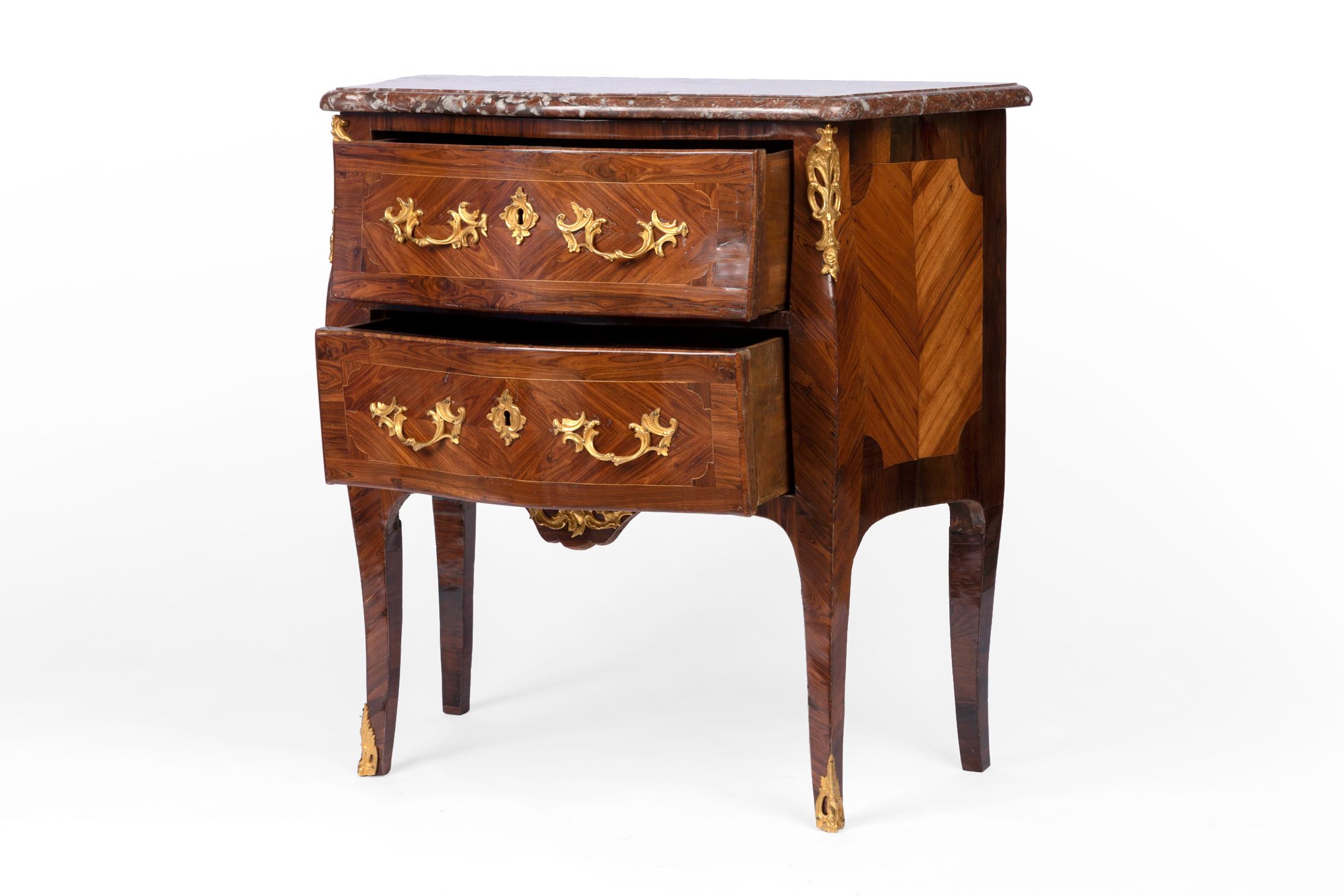 Louis XV period dresser, curved on the front and sides in rosewood veneer, violet wood, and Rio rosewood. Its front is decorated with two drawers in two rows and rests on curved legs
Engraved and gilded bronze ornamentation such as offsets,