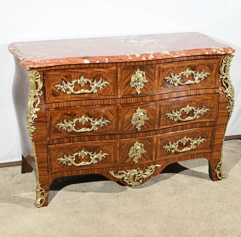 This kingwood chest of drawers opens with three drawers of identical dimensions, curved and rounded.
The fronts of these drawers are inlaid with kingwood veneer elements arranged vertically, horizontally, and diagonally, creating geometric yet