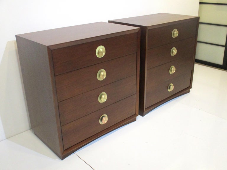 A pair of very well crafted dark walnut toned commodes / nightstand chests with turned brass pulls. The four drawers offer plenty of storage with the top drawer having dividers manufactured in the manner of the Widdicomb furniture company. A great