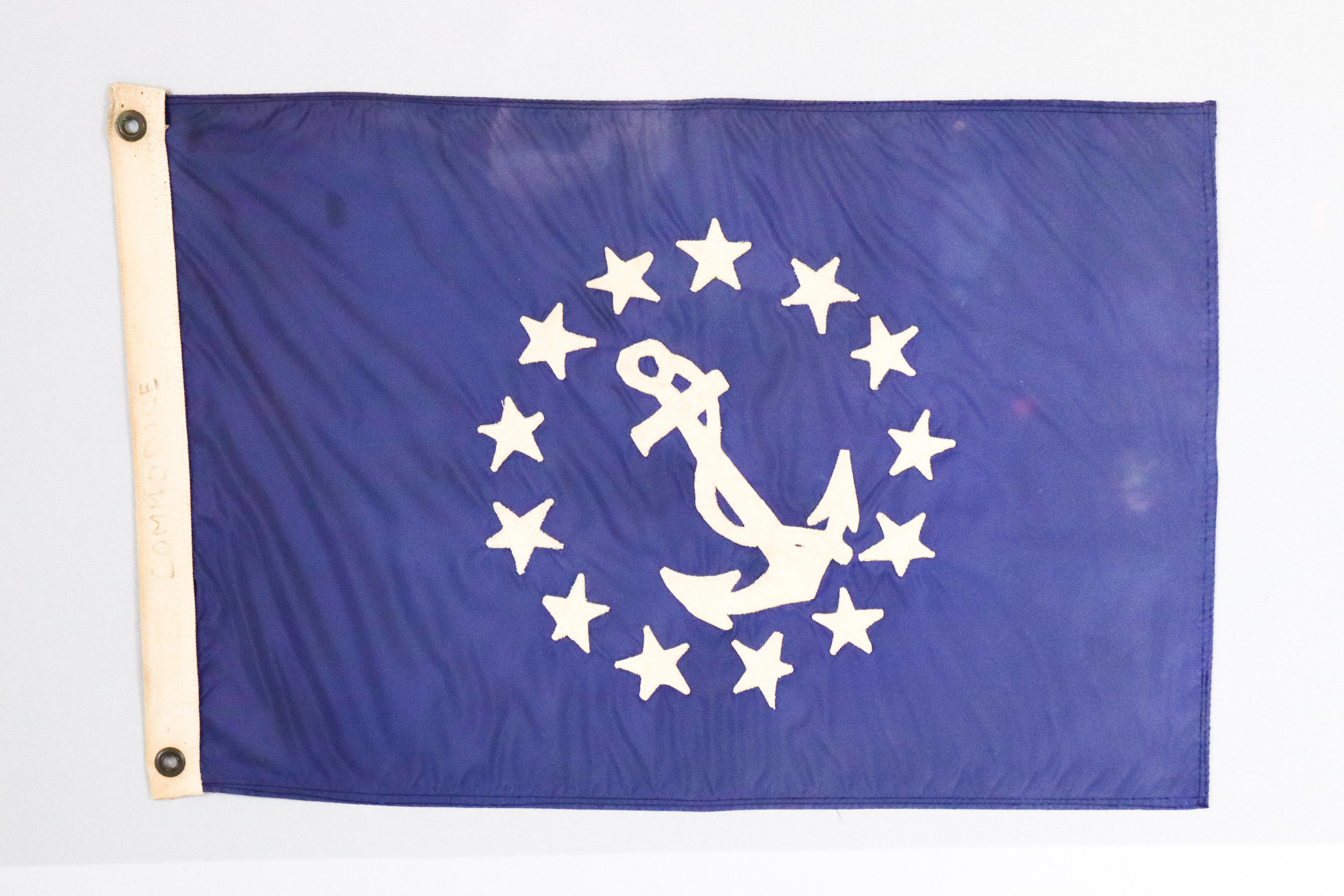 Yacht club Commodore's flag. Blue field surrounded by thirteen white stars. With cotton hoist and bras grommets. Mounted on gray matting and framed. Measures: 24