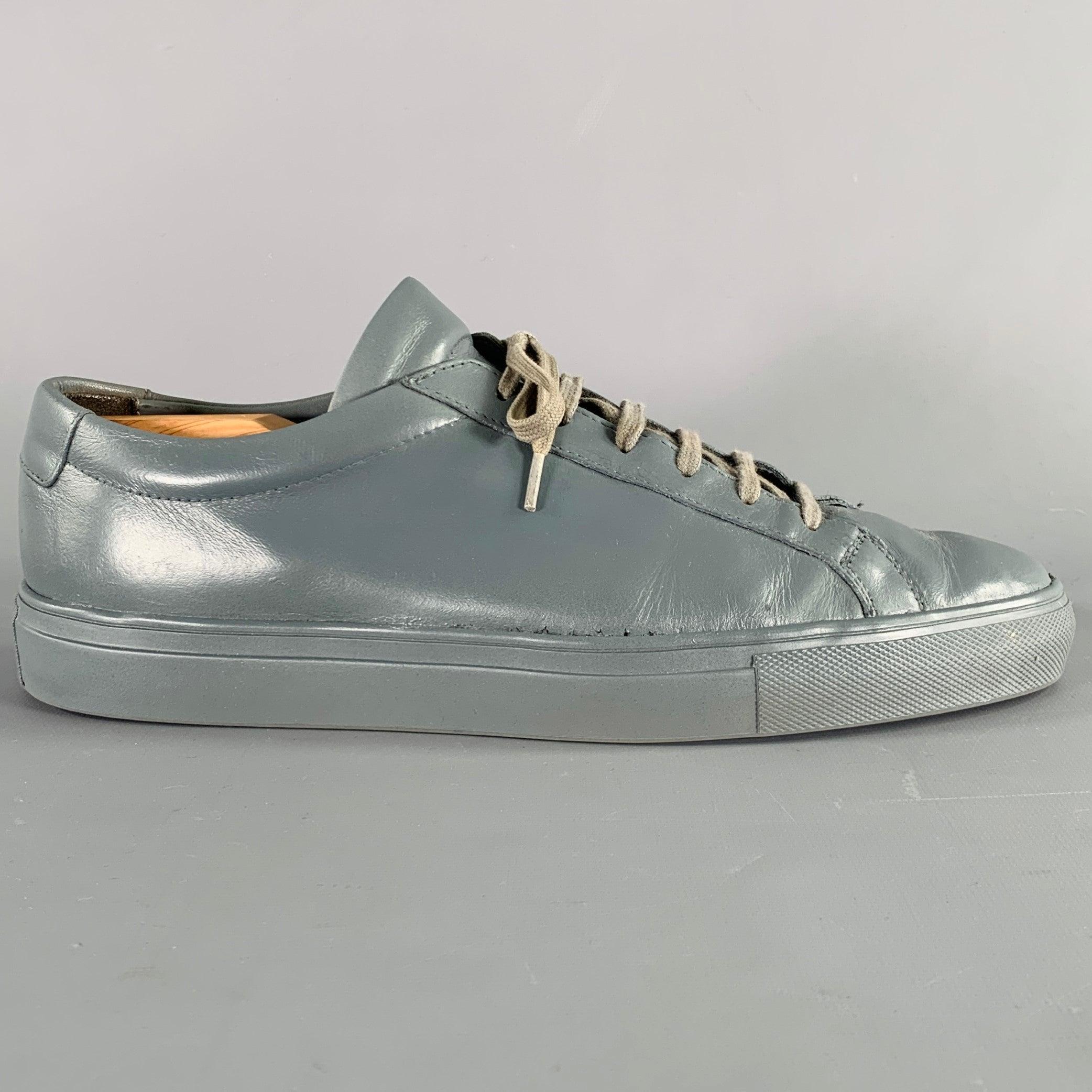 COMMON PROJECTS sneakers
in a grey leather featuring a low top style, rubber sole, and lace-up closure. Shoe trees not included. Comes with box. Made in Italy.Very Good Pre-Owned Condition. Serial numbers have been removed from sides of shoes. As