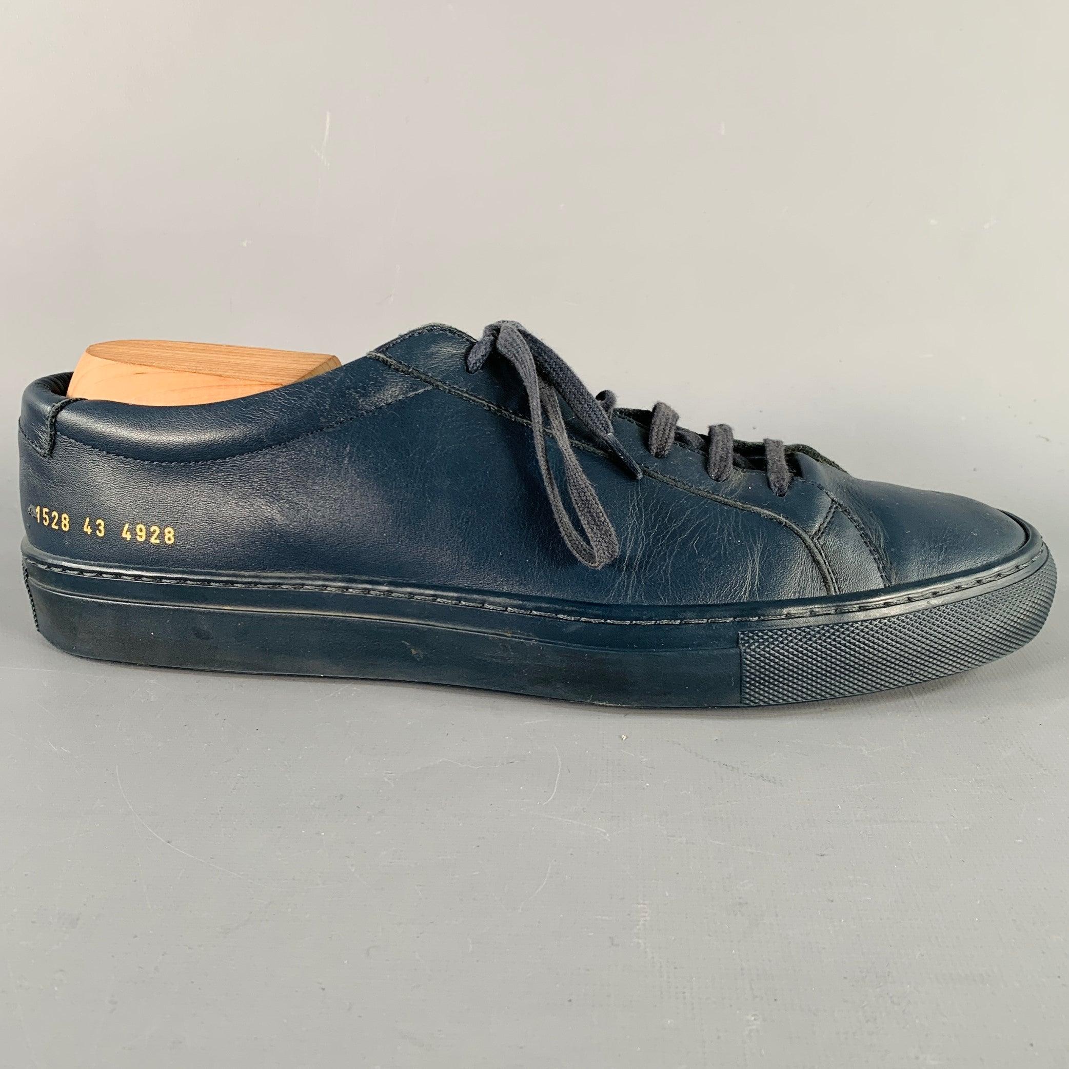 COMMON PROJECTS sneakers
in a navy leather featuring a low top style, rubber sole, and lace-up closure. Shoe trees not included. Made in Italy.Very Good Pre- Owned Condition. Signs of wear on heels. 

Marked:   1528 43 4928Outsole: 11.75 inches  x 4