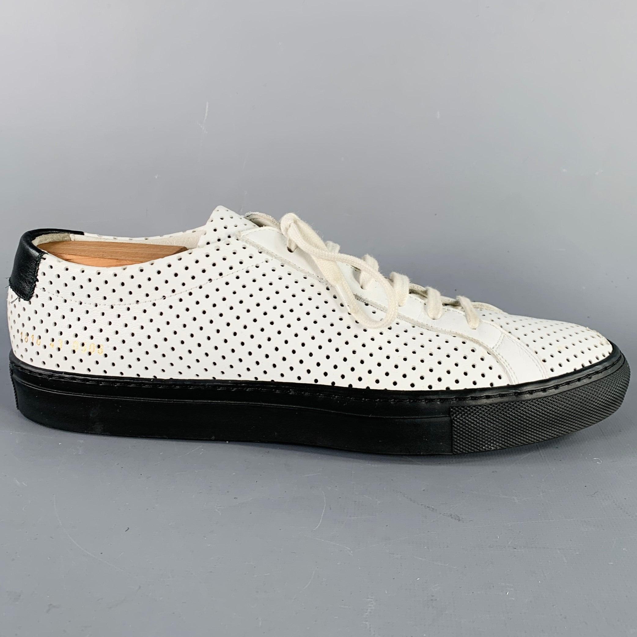 COMMON PROJECTS sneakers
in a white leather featuring a low top style, perforated design with black rubber sole, and lace-up closure.Shoe trees not included. Made in Italy.Very Good Pre- Owned Condition. Scuffs at toe. 

Marked:   1816 43