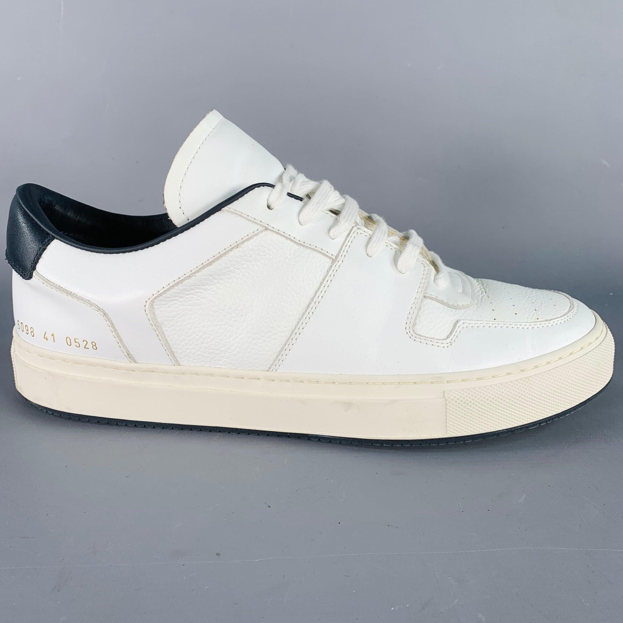 WOMAN by COMMON PROJECTS sneakers
in a white leather featuring a black trim, low top style, rubber sole, and lace-up closure. Made in Italy.Very Good Pre-Owned Condition. Minor signs of wear. 

Marked:   6098 41 0528Outsole: 11.25 inches  x 4 inches